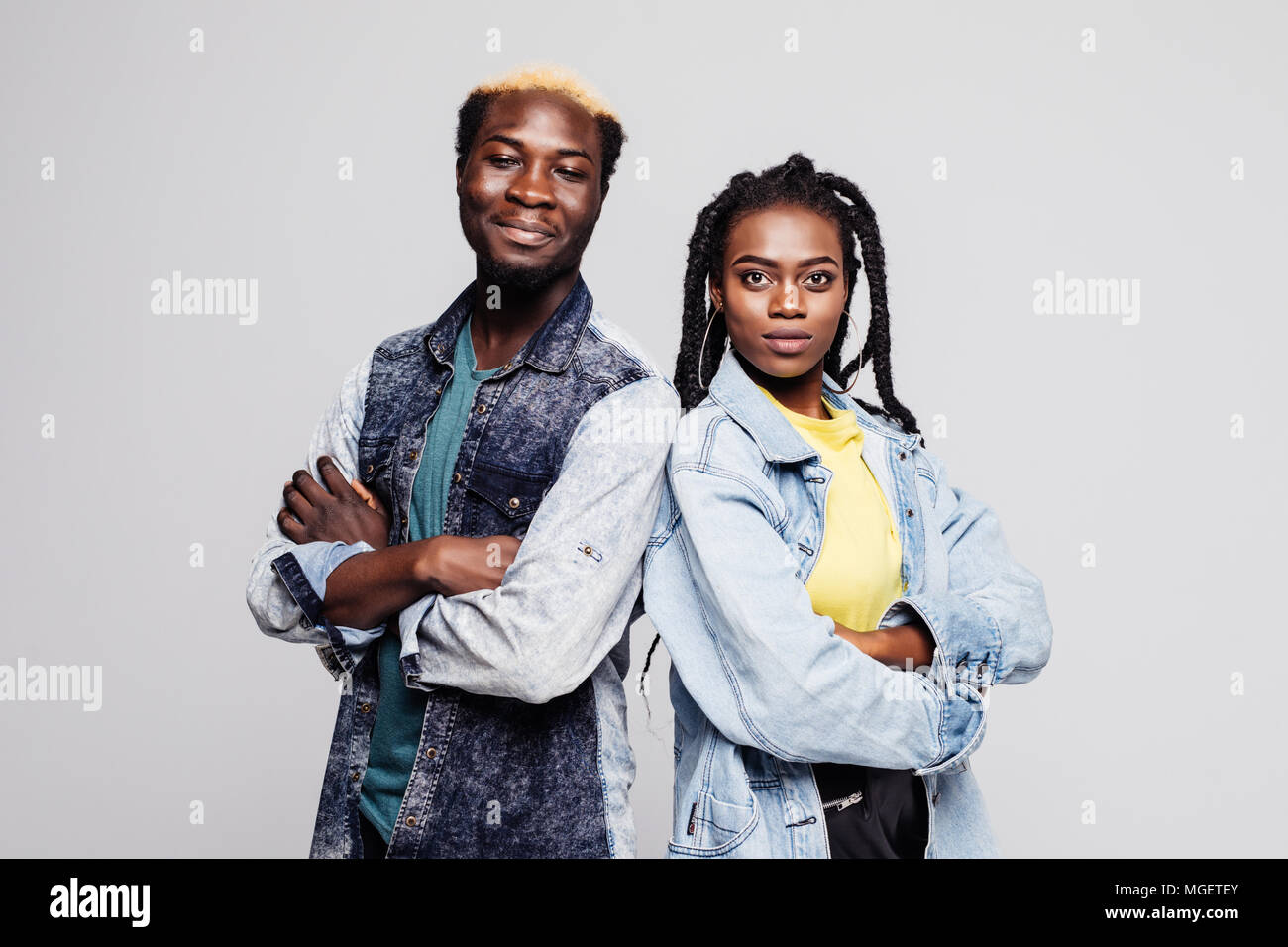 Portrait of an upset young afro american couple standing with arms folded isolated over white background Stock Photo