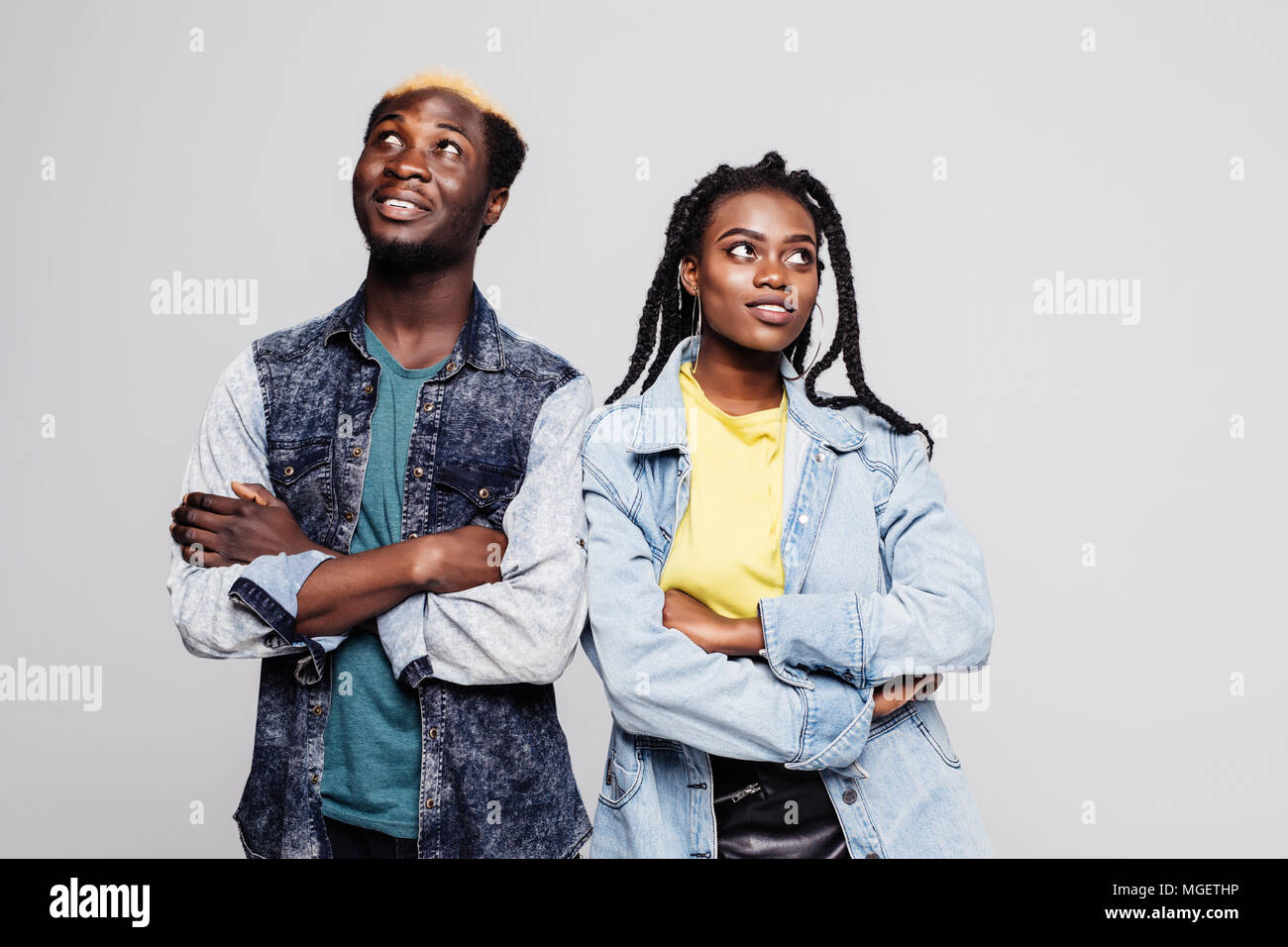 Portrait of an upset young afro american couple standing with arms folded and looking away isolated over white Stock Photo
