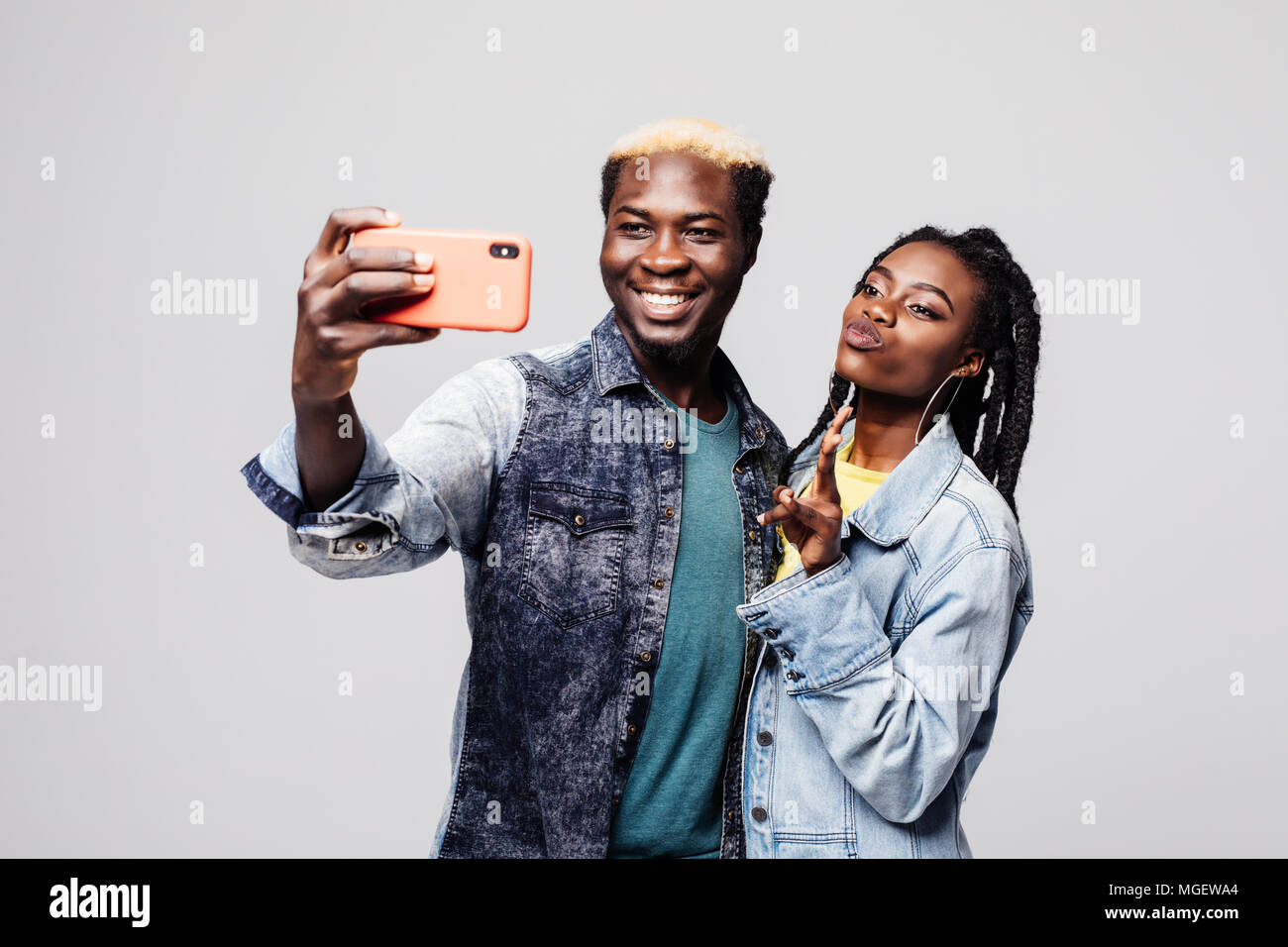 Portrait of a happy young african couple showing peace gesture while ...