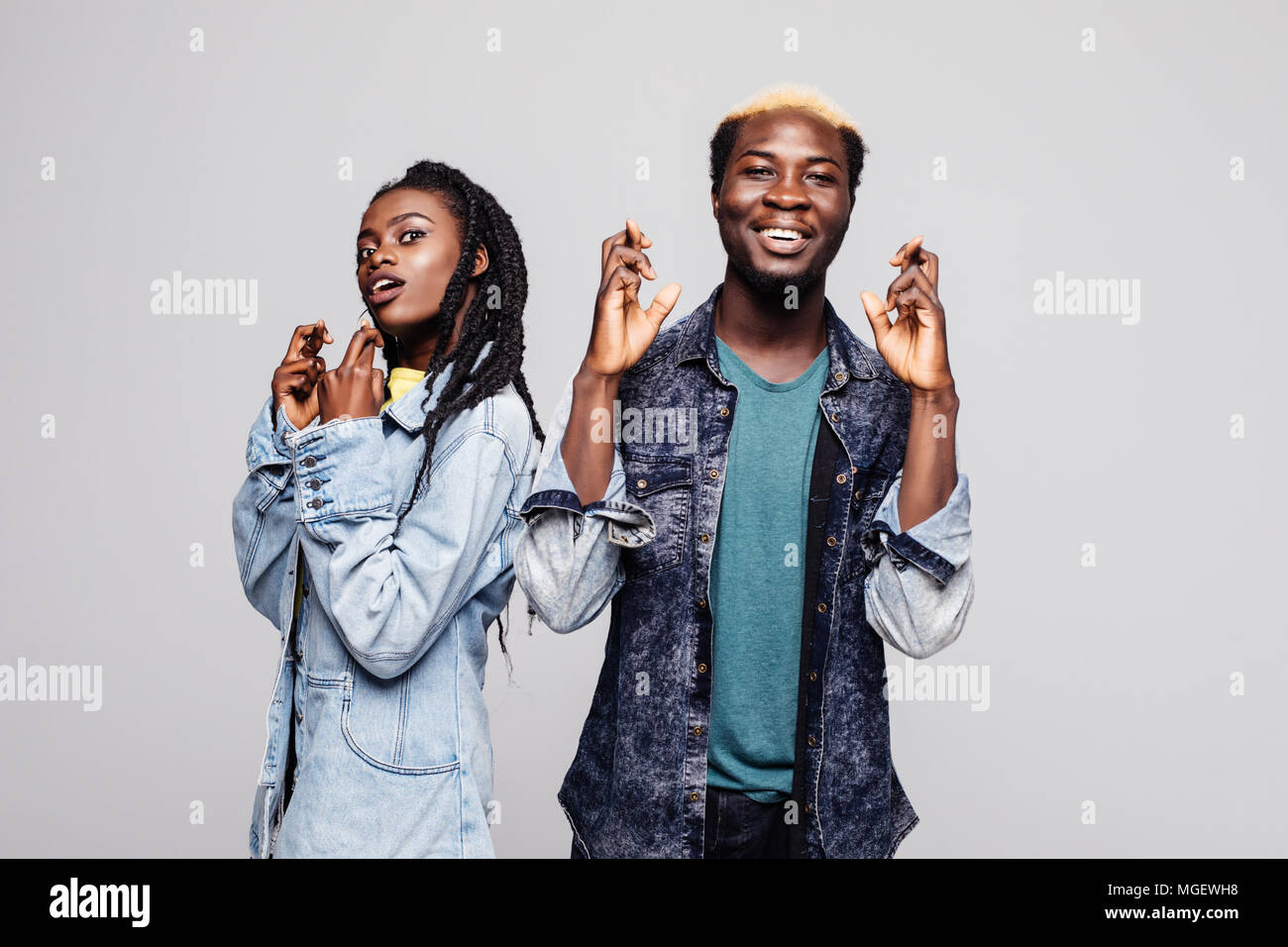 Portrait of an excited young african couple standing together and cross ...