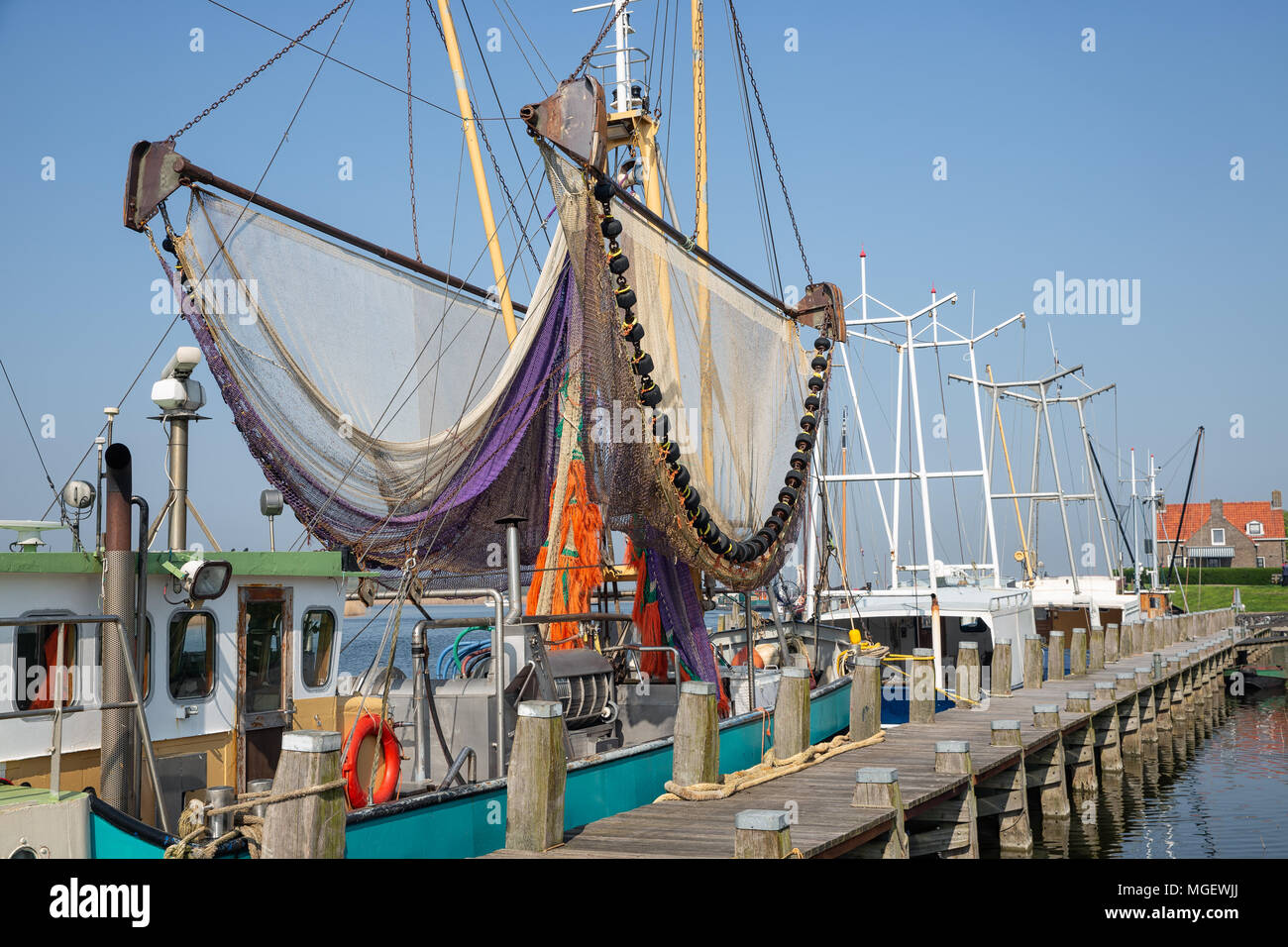 Harbor dutch fishing village Makkum with shrimp trawler drying nets Stock Photo