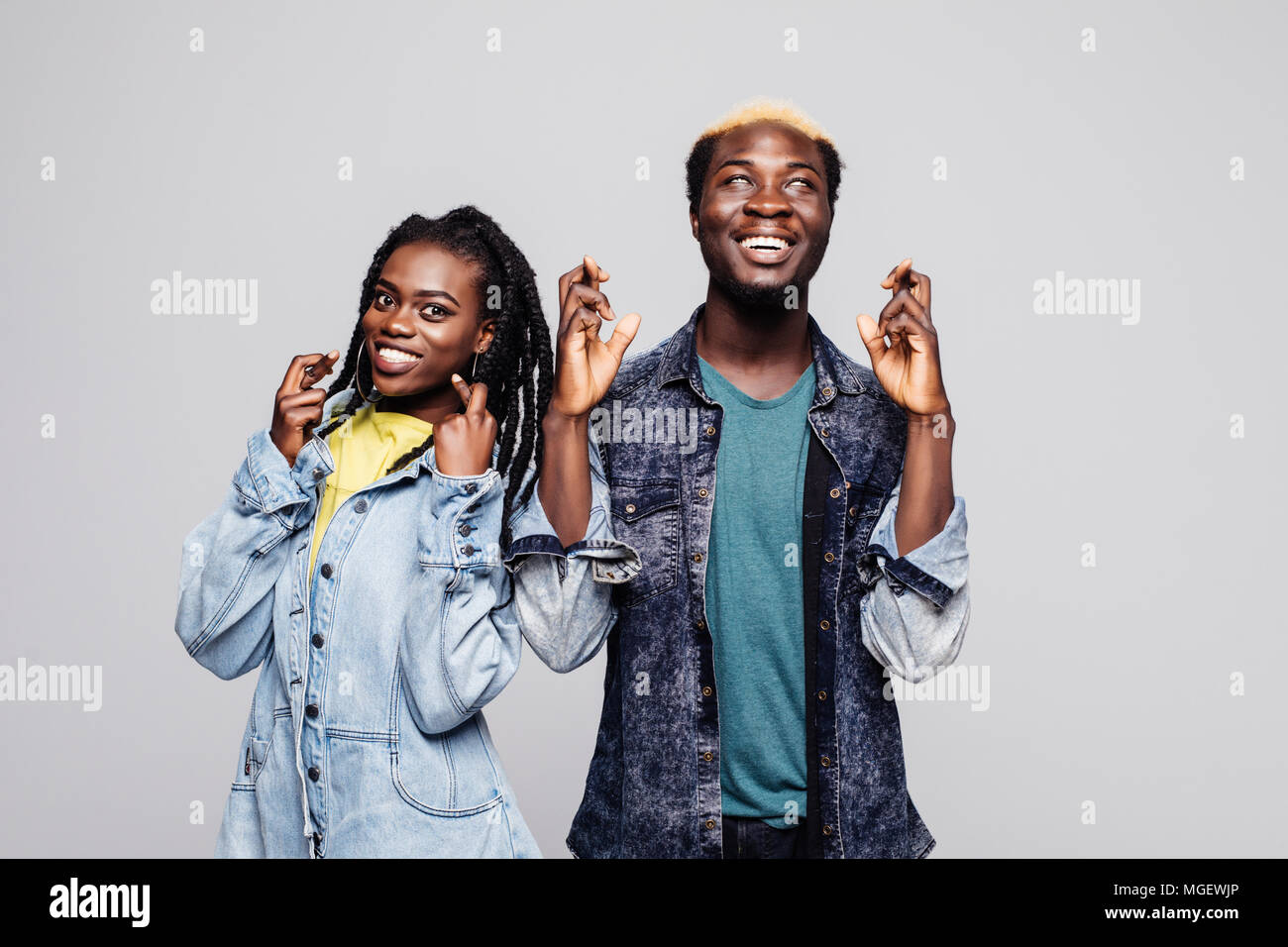 Portrait of an excited young african couple standing together and cross ...