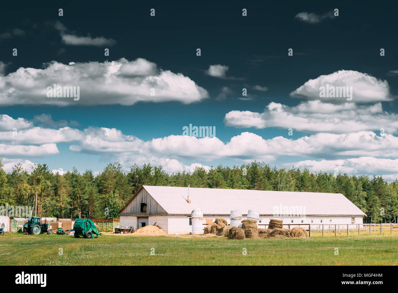 Countryside Rural Paddock For Horse, Shed Or Barn Or Stable With Haystacks In Late Summer Season. Agricultural Rural Farm Landscape At Sunny Day. Stock Photo