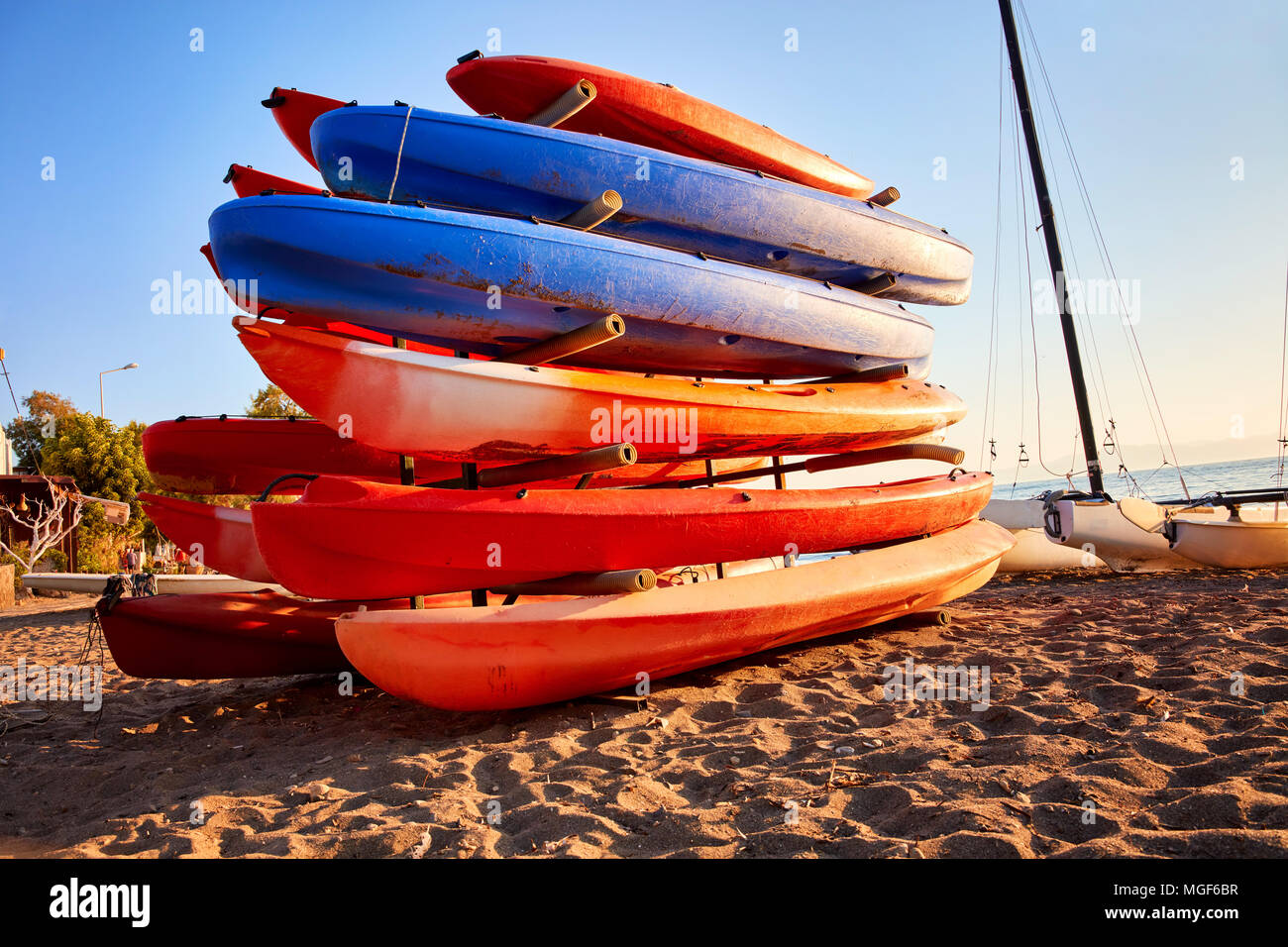 Colorful kayaks for hire on a canoe stand at the beach of a touristic vacation place Stock Photo
