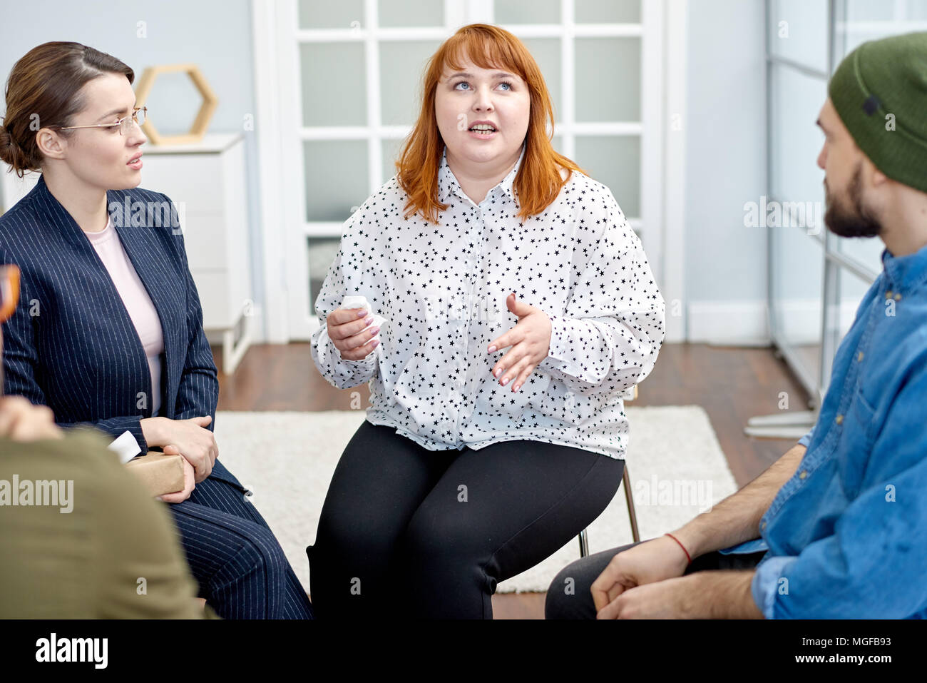 Profile view of pretty young psychologist listening to her obese