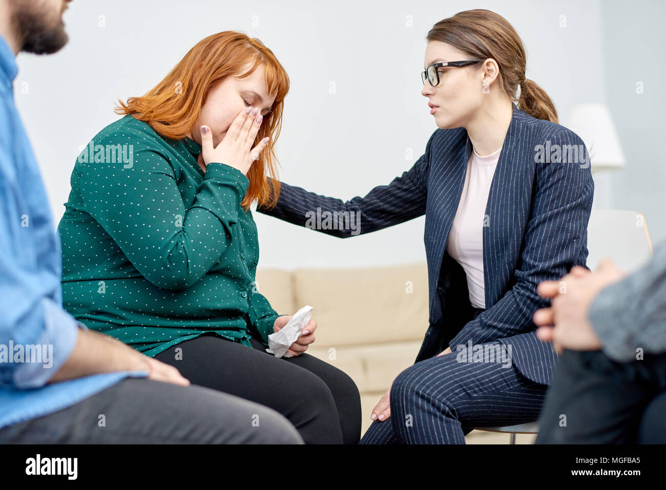 Highly professional psychiatrist comforting her crying obese patient