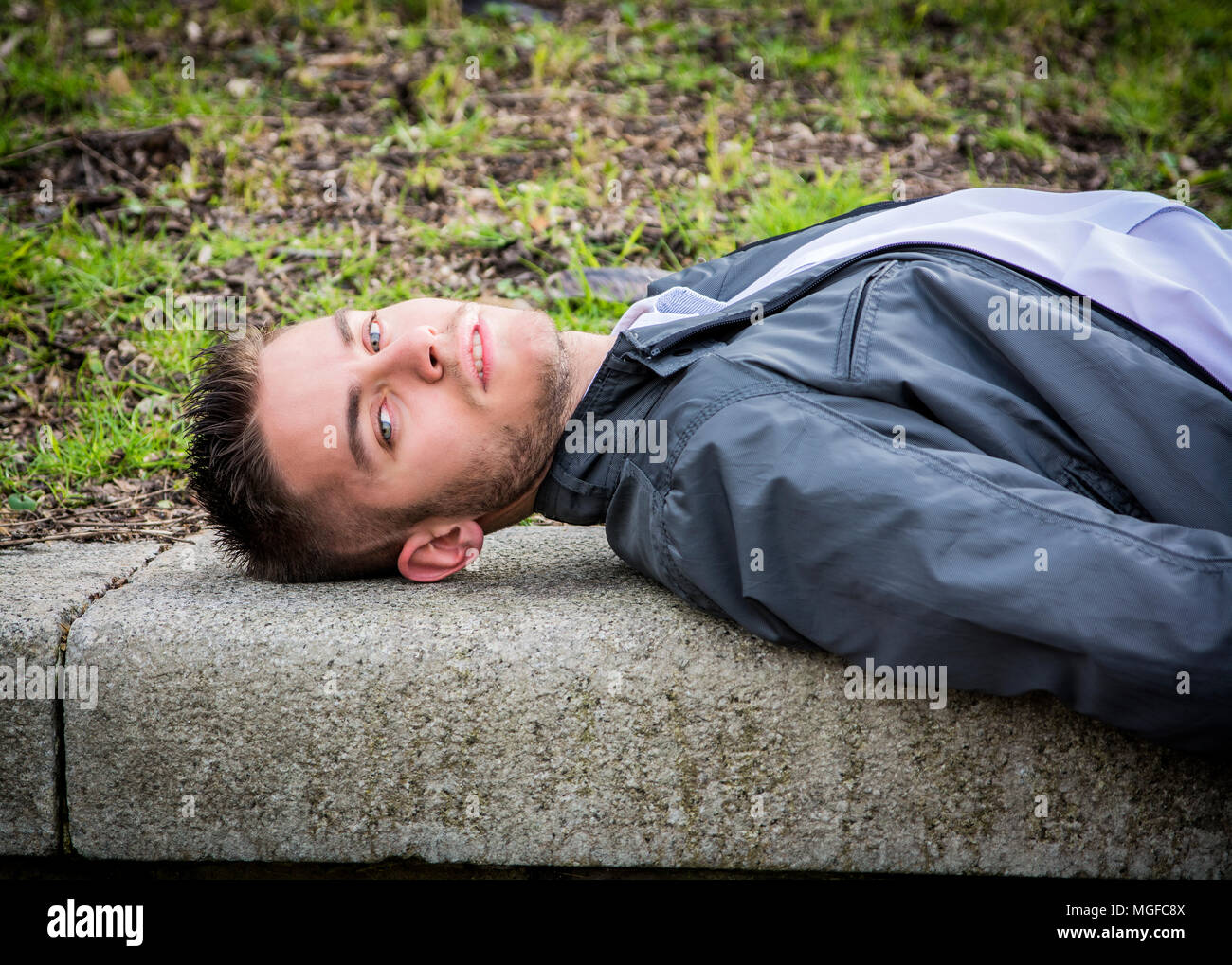 Handsome young man looking at camera in park Stock Photo