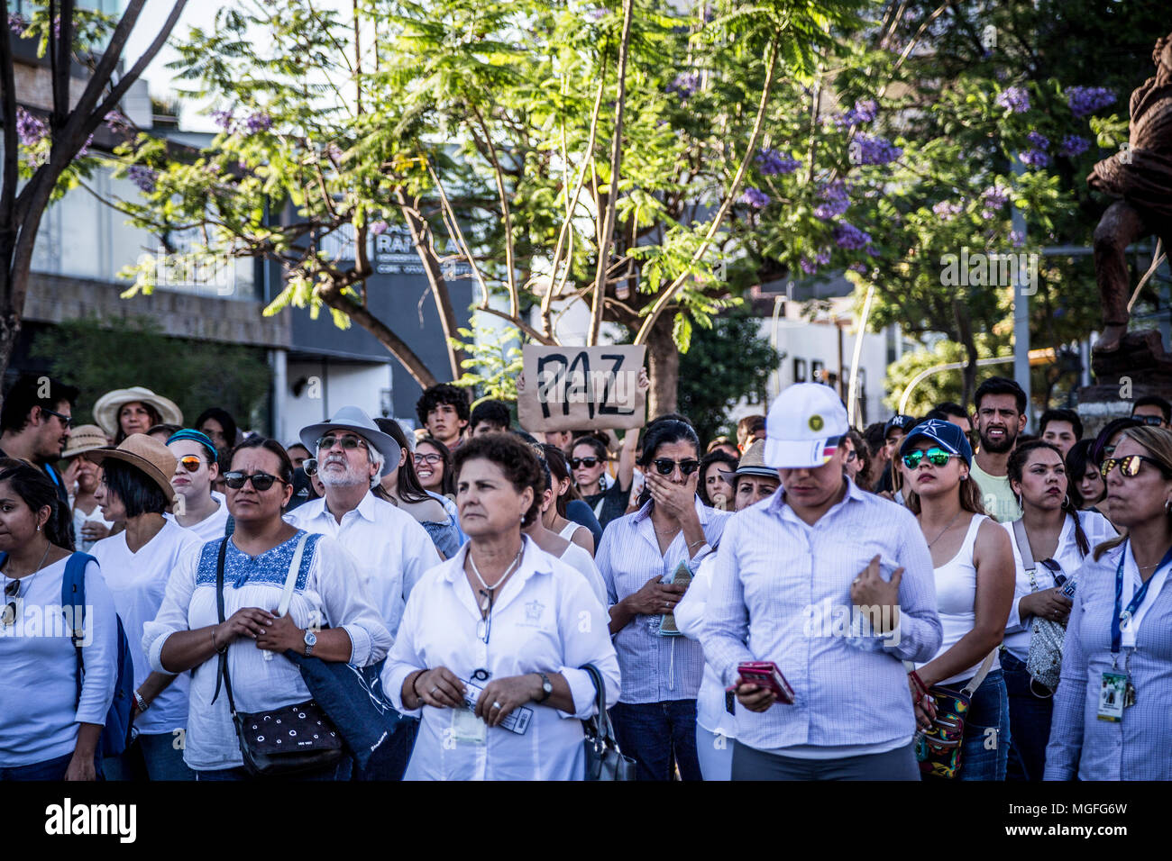 26 April 2018, Mexico, Guadalajara: Demonstrators take to the streets with one of them carring a hand-written sign which reads 'Paz' (peace) during a protest march following the murder of three film students. Mexico is currently experiencing an unprecedented surge in violence, marking 2017 the bloodiest year in the country's recent history with more than 29,000 homicides and around 30,000 people presumed missing. Photo: Toni Rodriguez/dpa Stock Photo