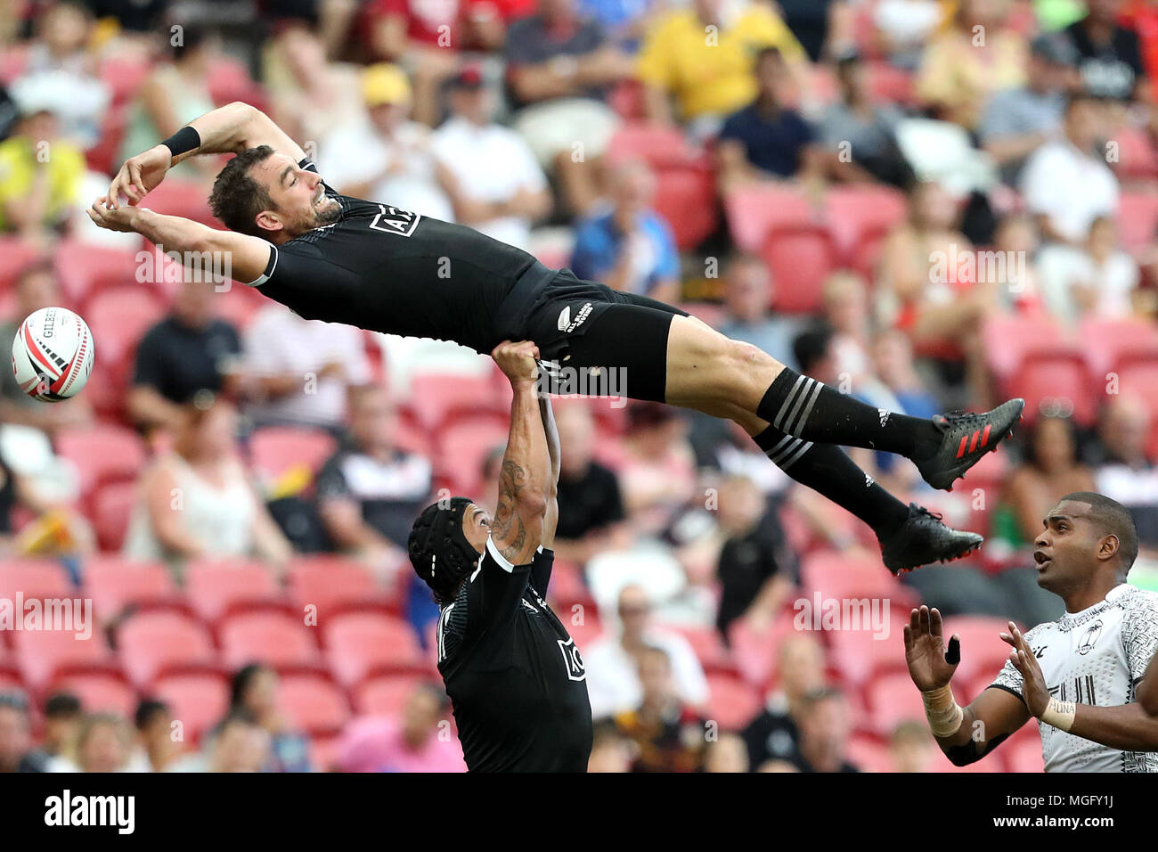 Singapore. 29th Apr, 2018. Kurt Baker (left) of New Zealand misses the ball as he is lifted by Trael Joass (centre) during the Cup Quarter Final match between Fiji and New Zealand at the Rugby Sevens tournament at the National Stadium. Singapore. Credit: Paul Miller/ZUMA Wire/Alamy Live News Stock Photo