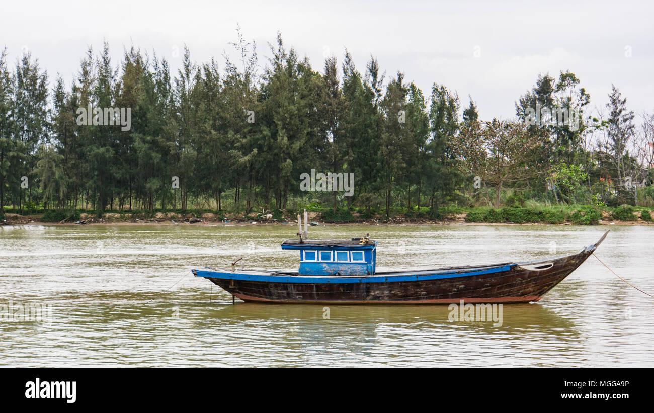one old fishing boat anchored on the side of the river Stock Photo - Alamy