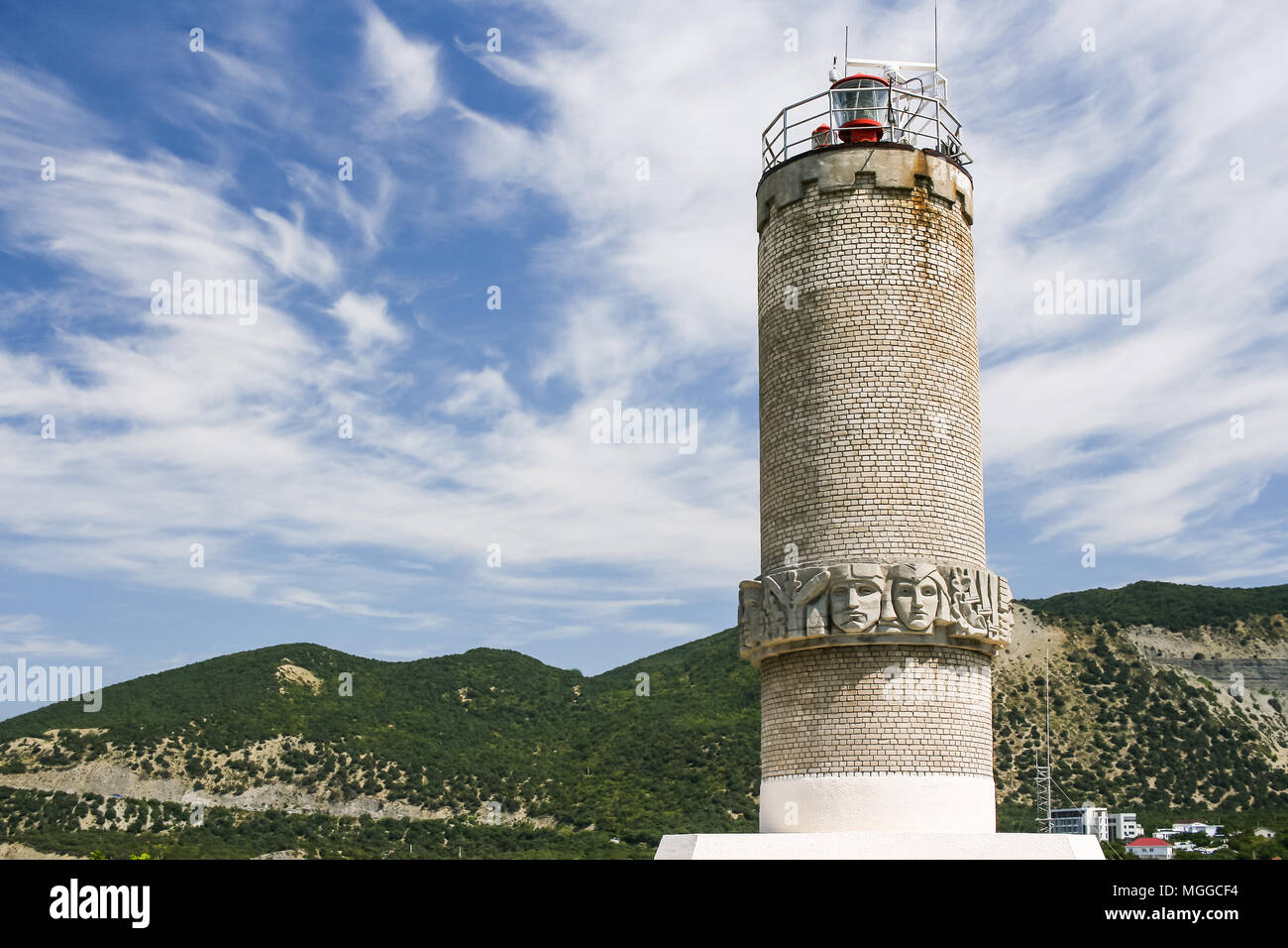 Close-up lighthouse on the Black sea coast on the Peninsula Bolshoy Utrish, Russia against Caucasus mountains and sky. Stock Photo