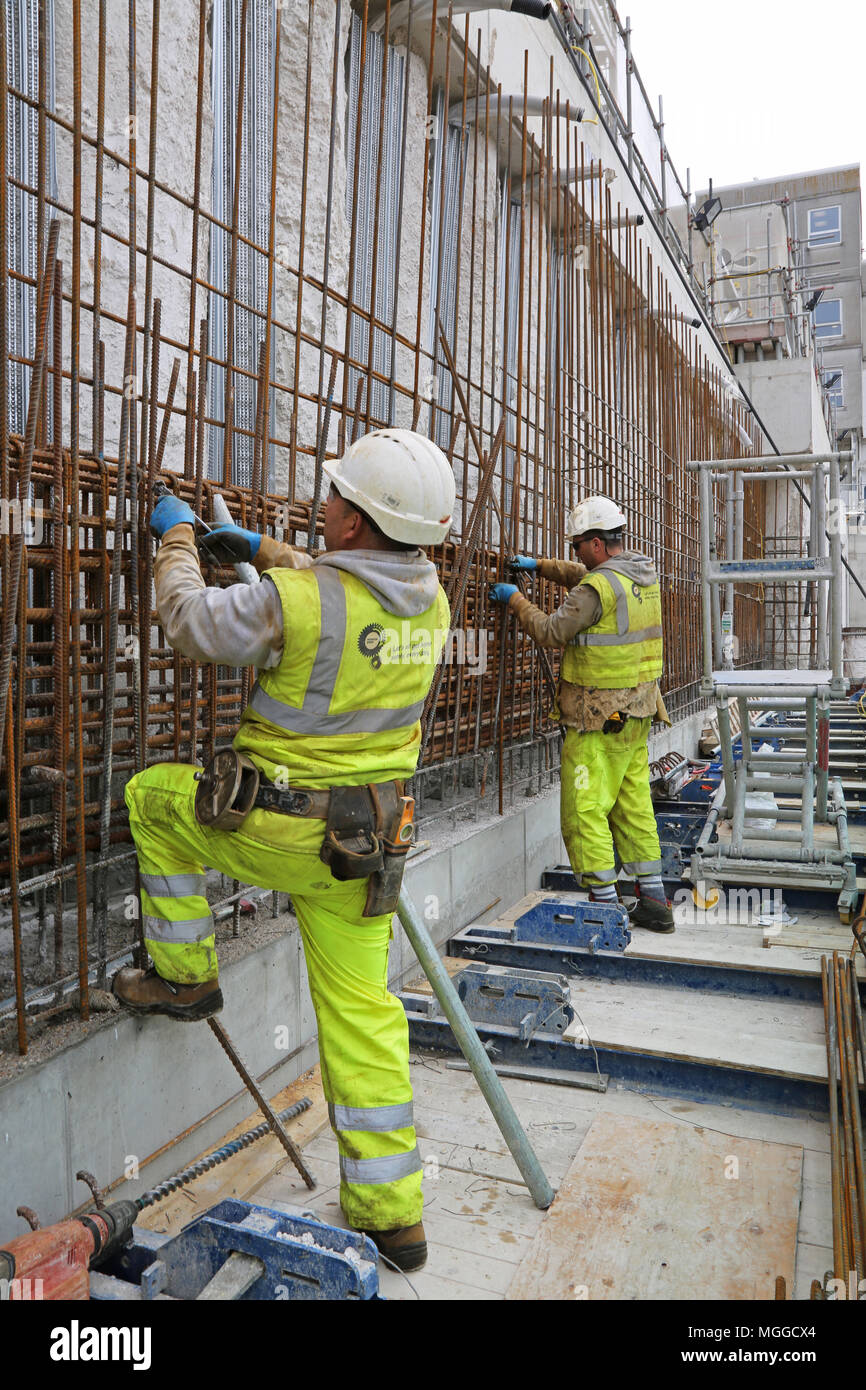 Construction of the new extension to Brighton's Royal Sussex Hospital. Shows workmen assembling steel reinforcement for concrete basement walls.. Stock Photo