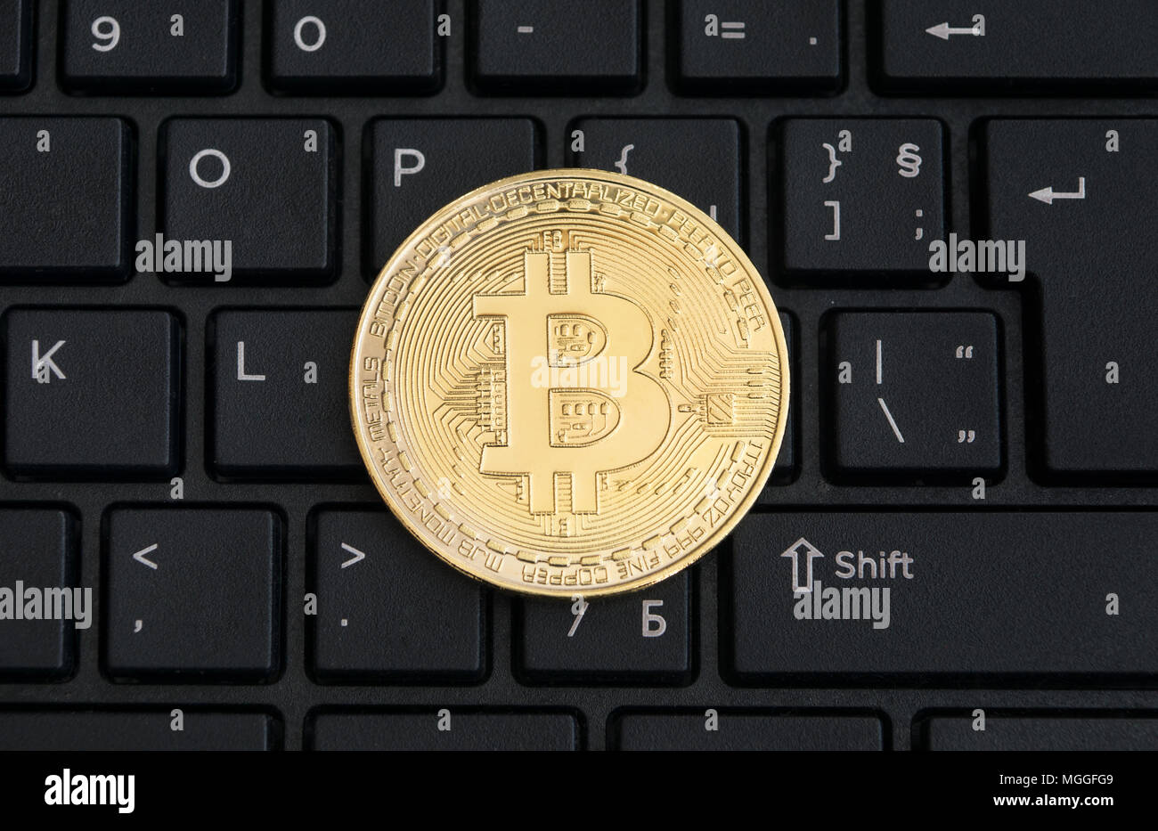 Abstract golden bitcoin on a black computer keyboard Stock Photo