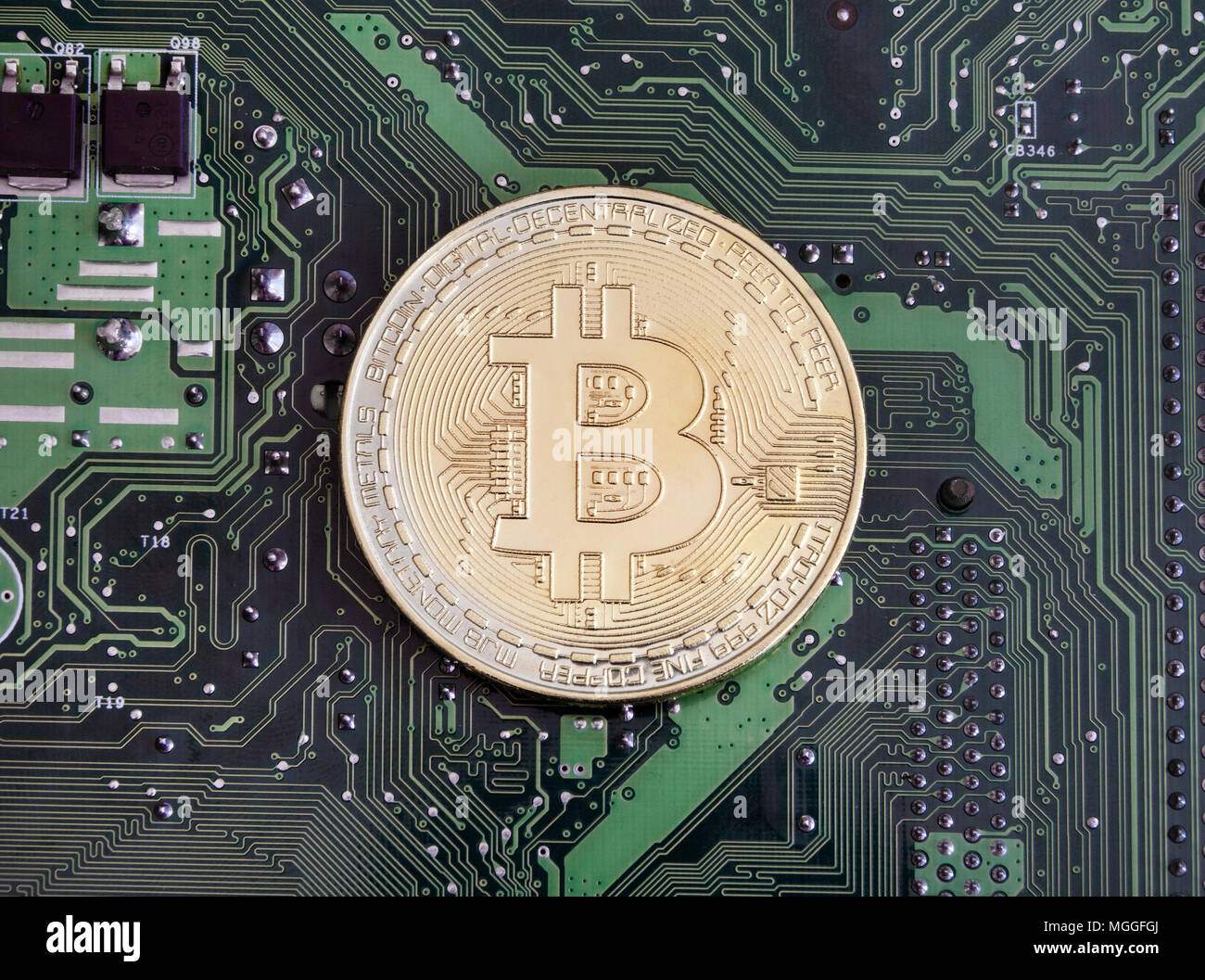 Abstract golden bitcoin on printed circuit board Stock Photo