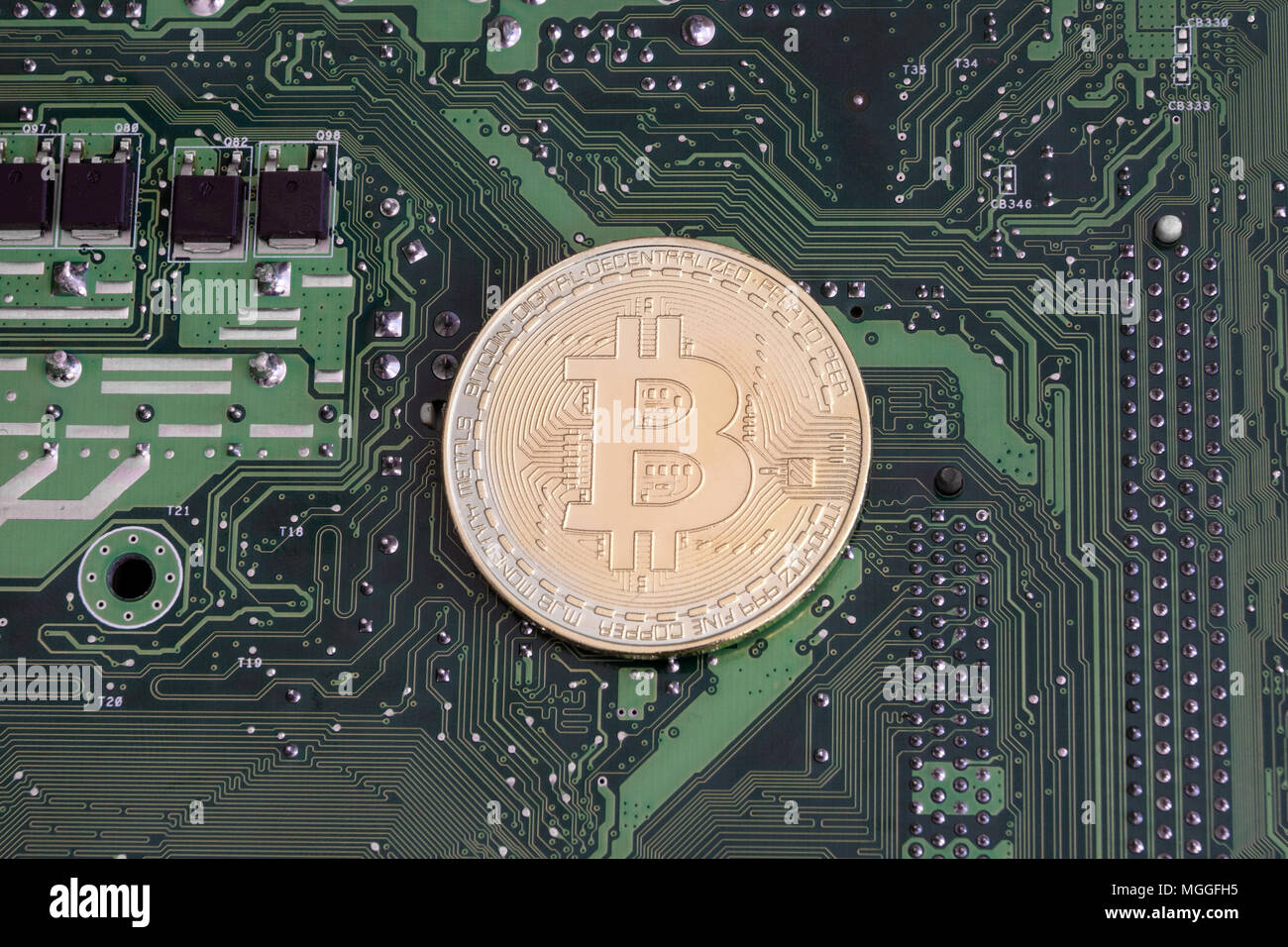 Abstract golden bitcoin on printed circuit board Stock Photo