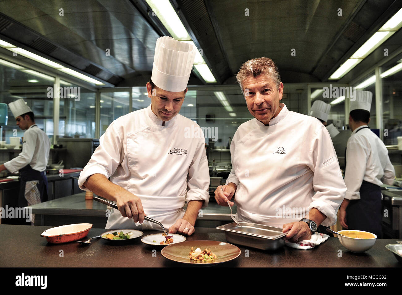 Three-starred chef Régis Marcon (right) at work with his son Jacques (left) in the kitchen of his restaurant in Saint-Bonnet-le-Froid, France Stock Photo