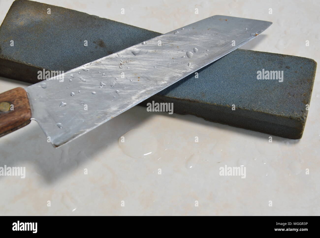 kitchen knife blade on grindstone Stock Photo - Alamy
