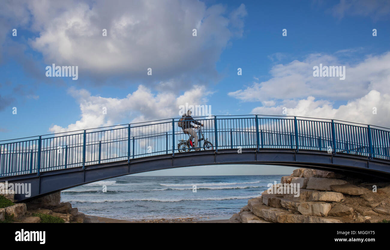 A bicycle rider on a bridge, looking at the ocean Stock Photo - Alamy