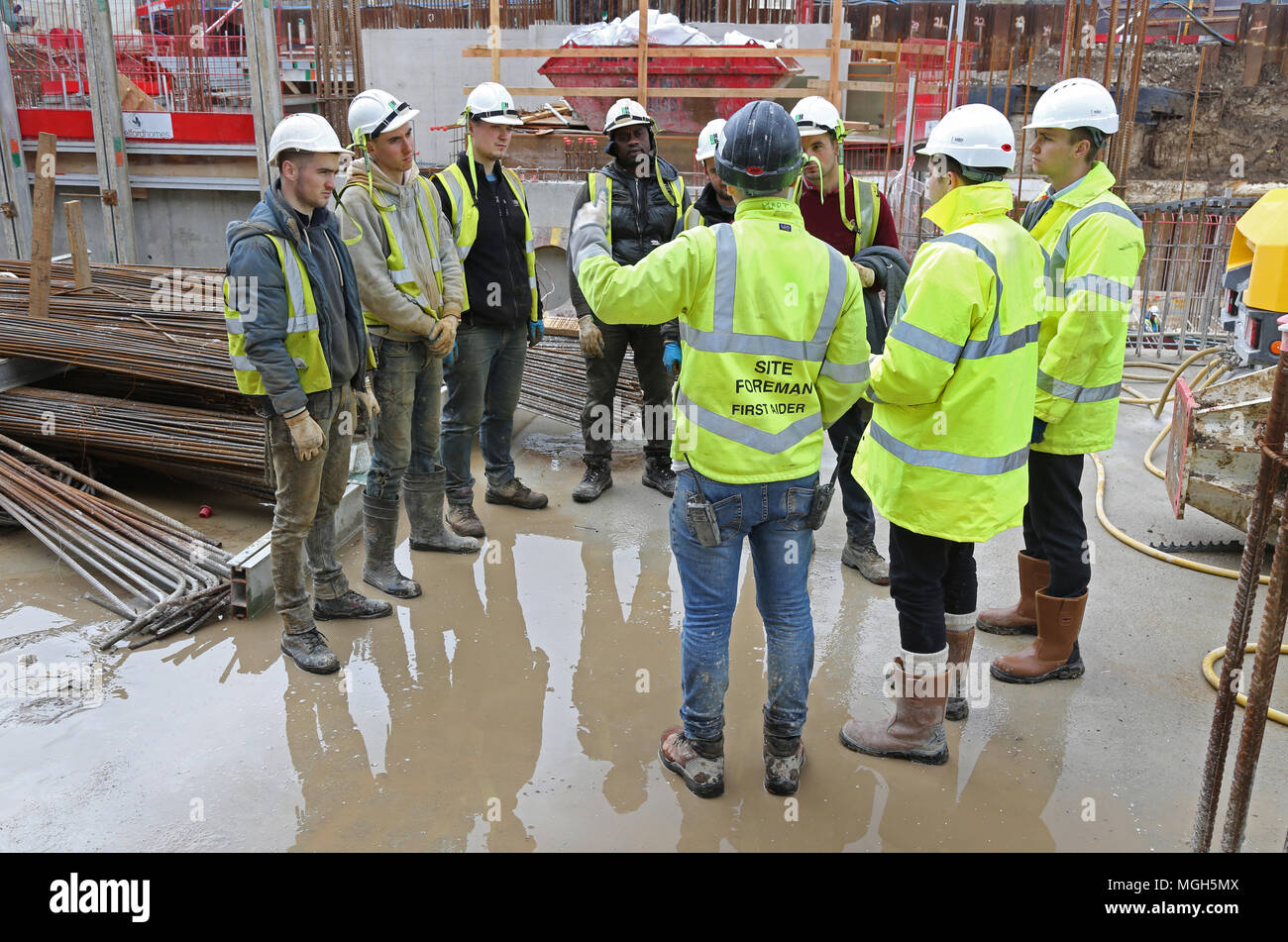 A 'Toolbox Talk' takes place on a London building site. Site staff receive training and project information from the senior project management team Stock Photo