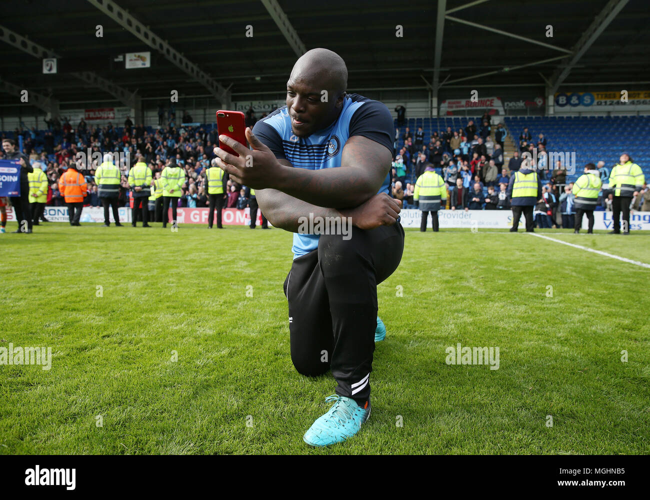 Wycombes Adebayo Akinfenwa celebrates promotion to League One with a live video blog during the Sky Bet League Two match at the Proact Stadium,Chesterfield Stock Photo