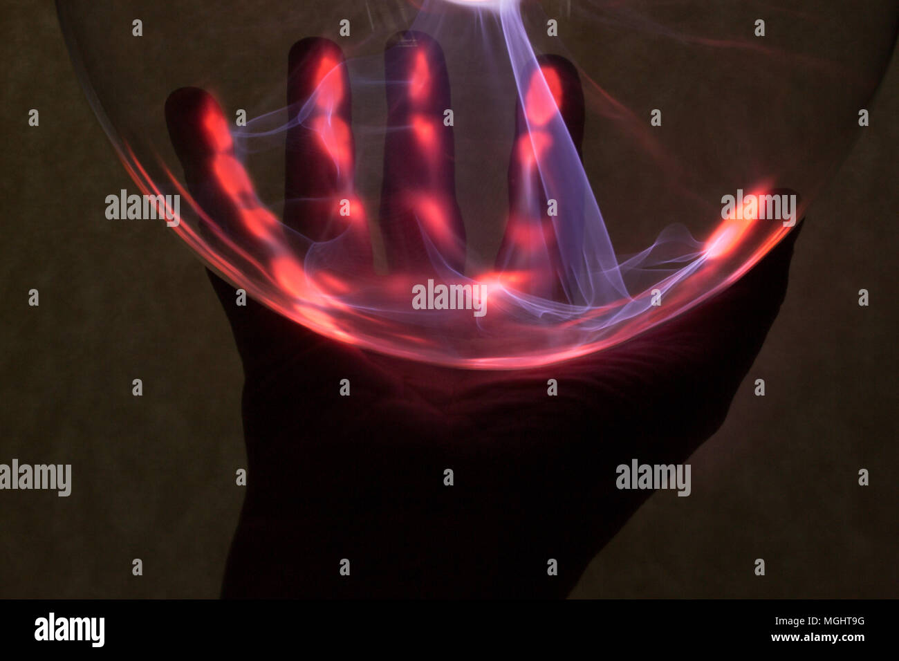 In the background is the hand that was illuminated by plasma from plasma lamp. Stock Photo