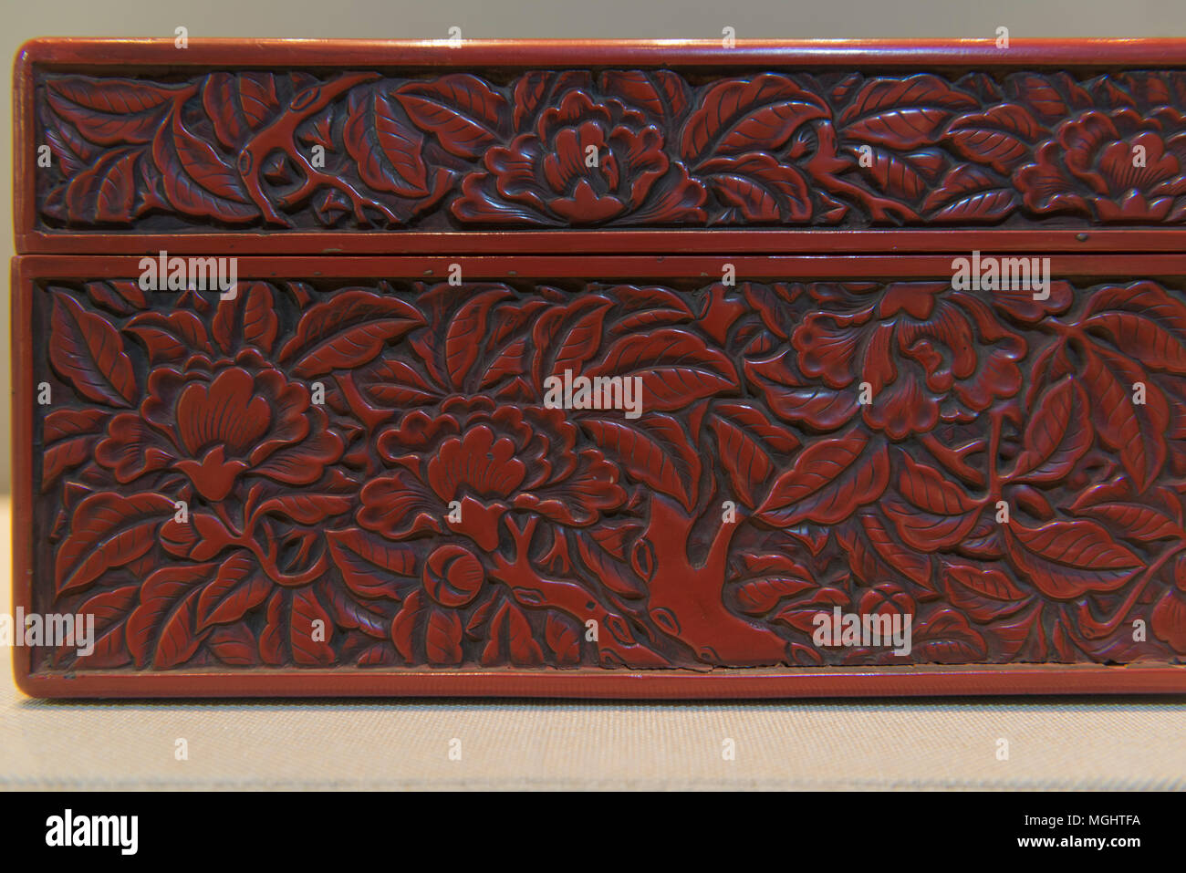 A rectangular vermilion box with craft of carved lacquer over wood from