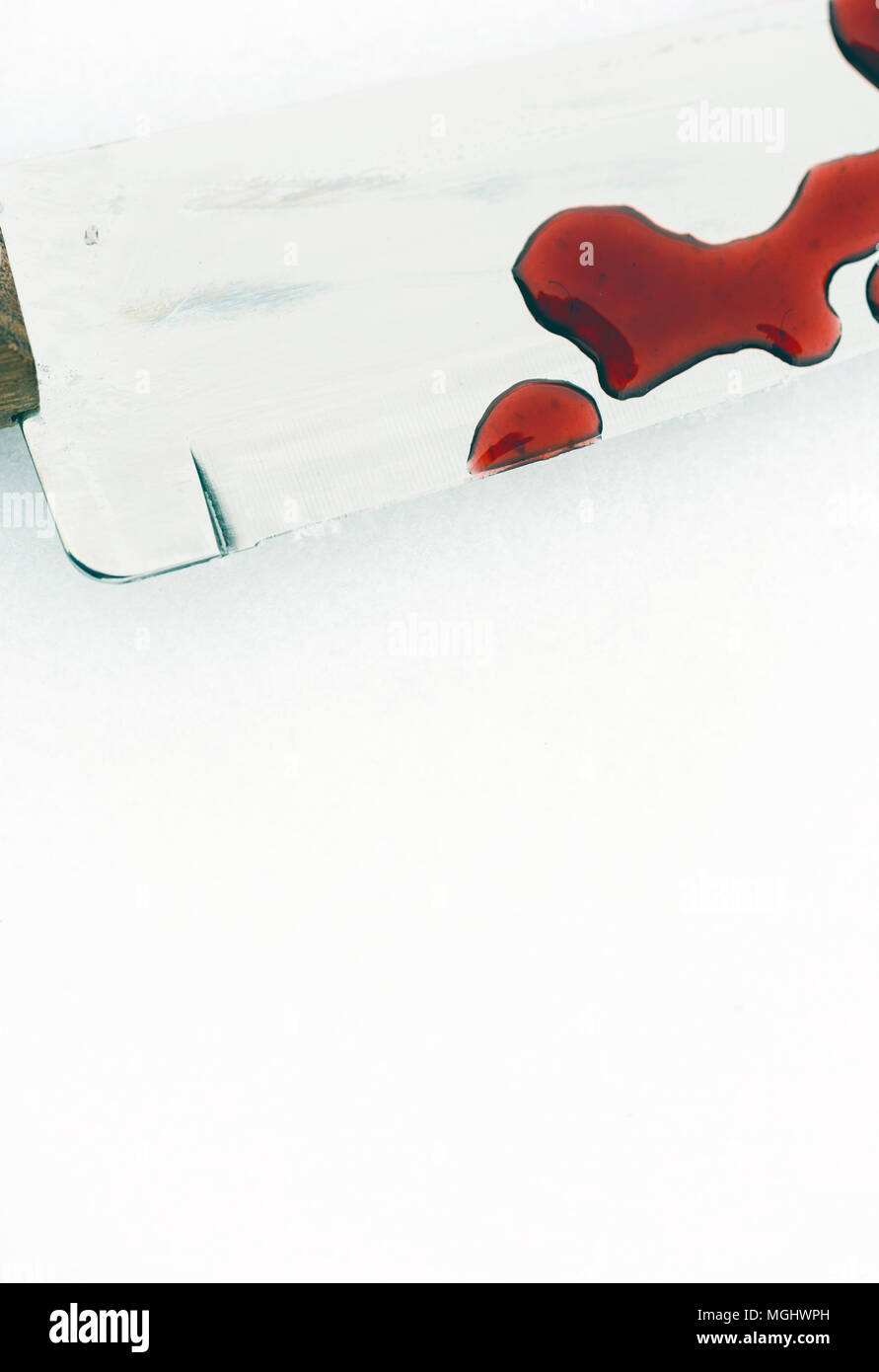 Sharp metal kitchen knife edge used as a violent murder weapon with blood drops on a white snow background. Blade covered in violence with copy space  Stock Photo