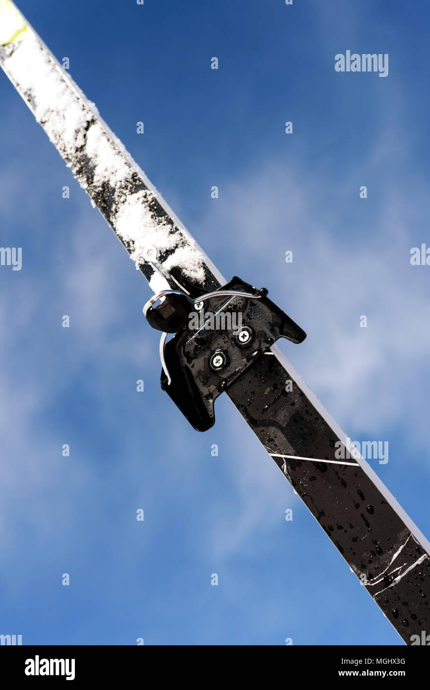 Single new cross-country ski set against a blue winter sky with defocused clouds in the background with a copy space area for wintery themed sports an Stock Photo