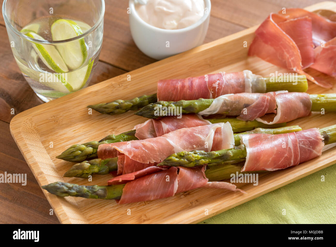 Asparagus wrapped in ham on board Stock Photo Alamy