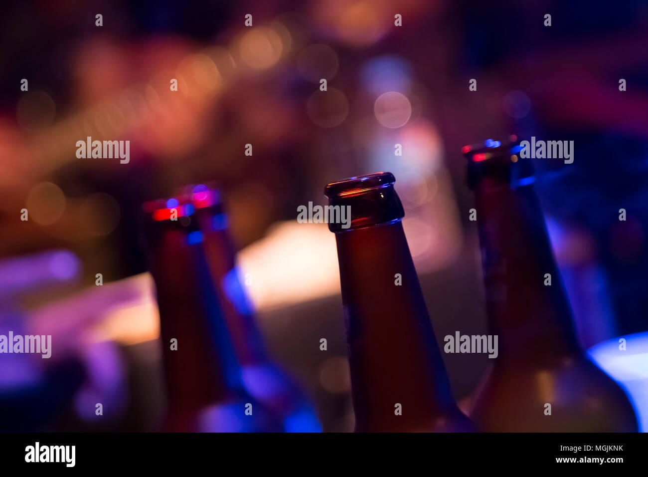 Beer bottles close up in dark bar environment hires stock photography
