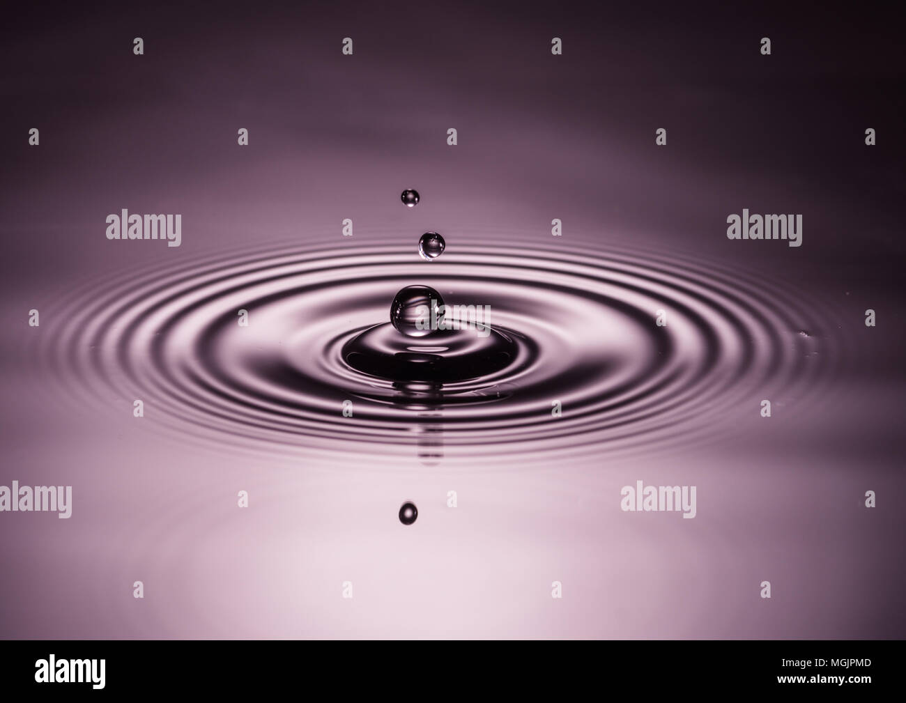A macro shot of water drops falling into a pool of water Stock Photo ...