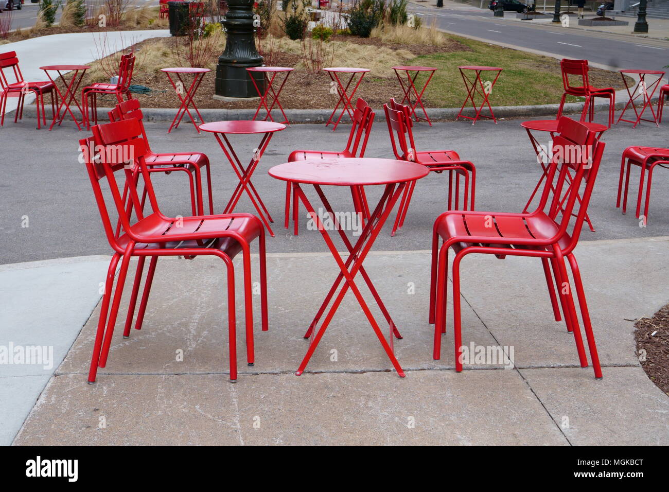 A set up of red chairs waiting for the customers during a cold day of April. Stock Photo