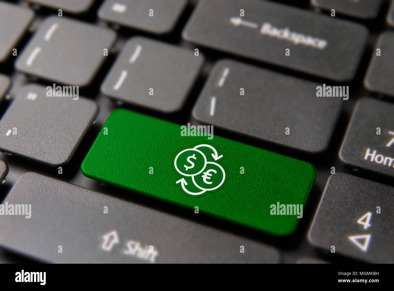 Online currency exchange concept: green key button with dollar conversion to euro icon on laptop keyboard. Stock Photo