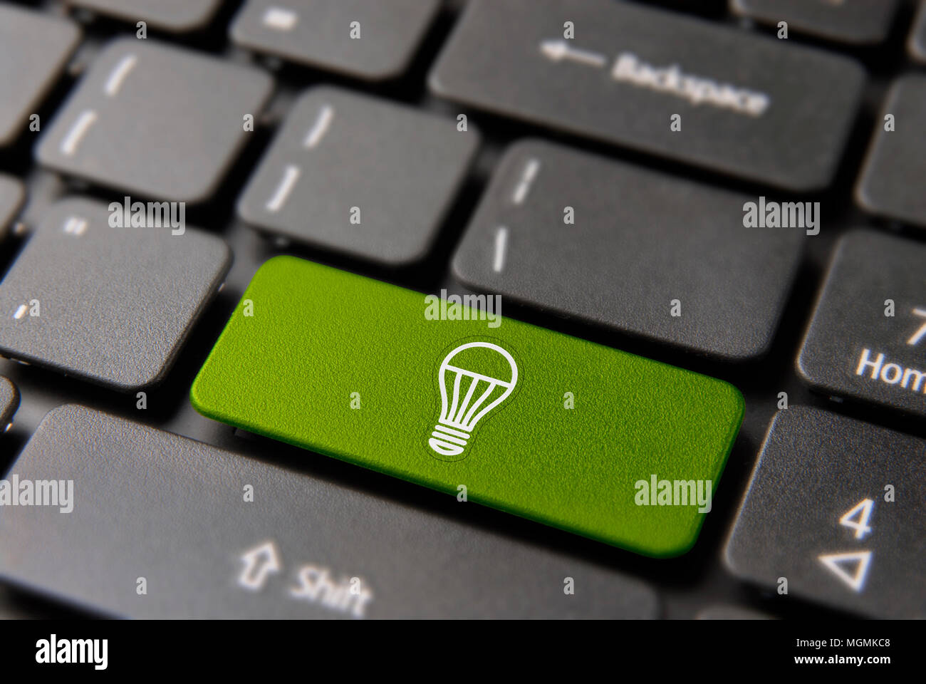 Green energy concept. Eco friendly computer keyboard button with ecological light bulb  icon on color keypad for environment help. Stock Photo