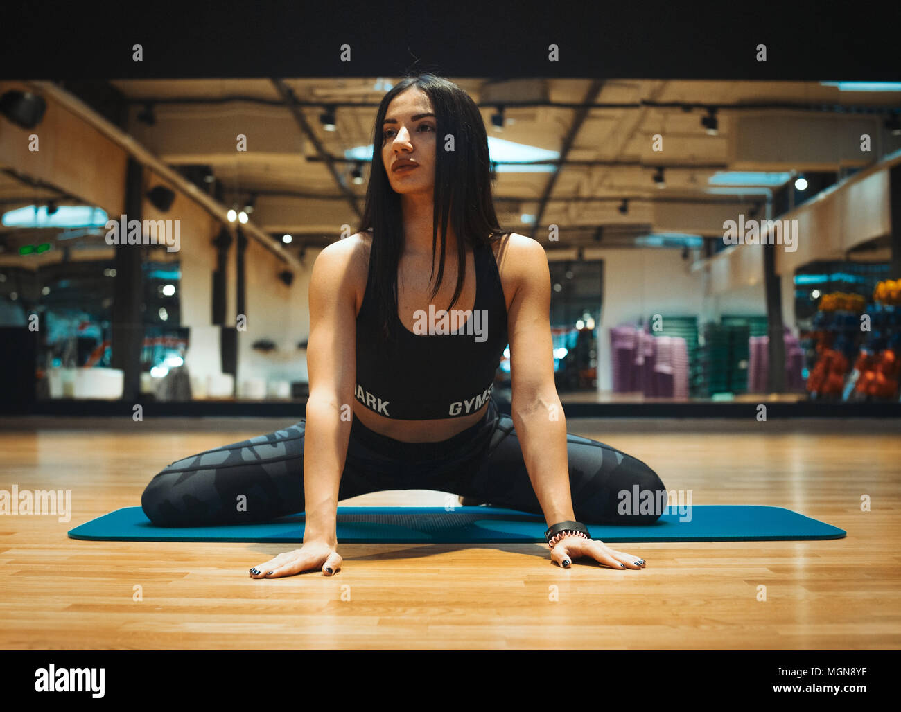Young brunette girl stretching in gym Stock Photo - Alamy