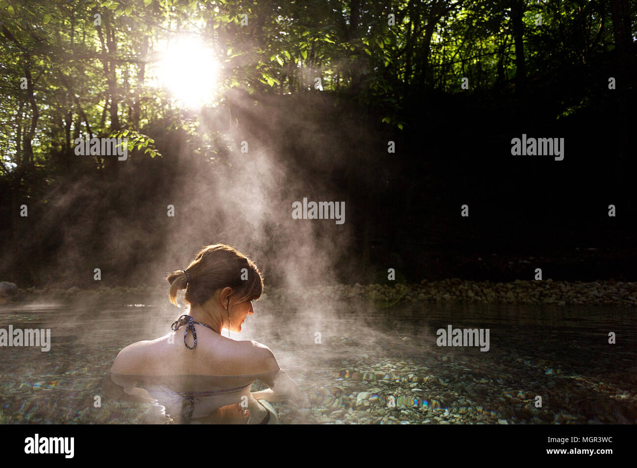 Woman relaxing in natural hot spring in the forest, Maibachl, Austria, Europe. Stock Photo