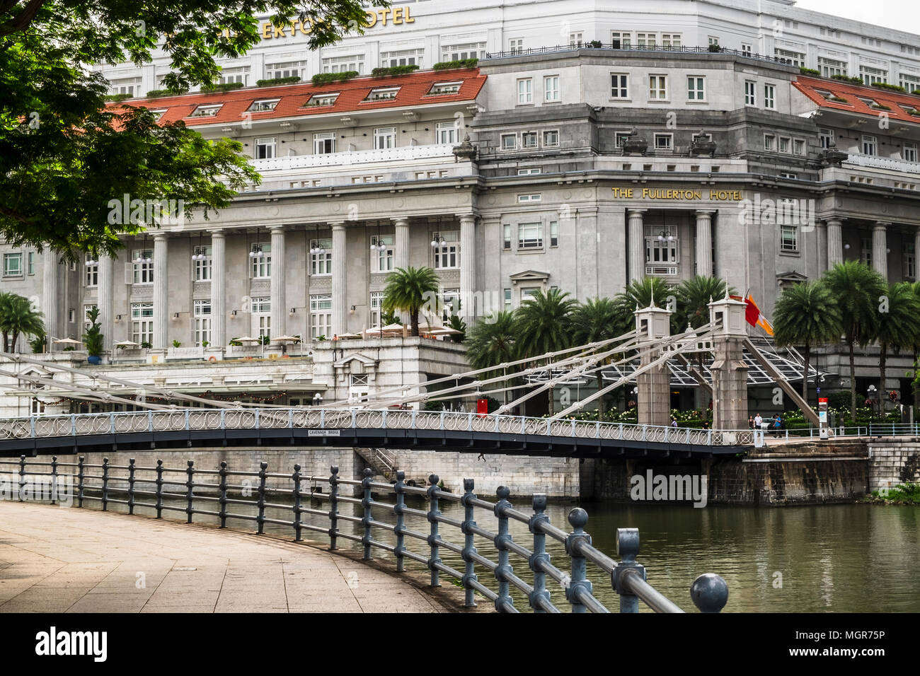 Cavenagh Bridge with The Fullerton Hotel in backgrouond, Singapore Stock Photo