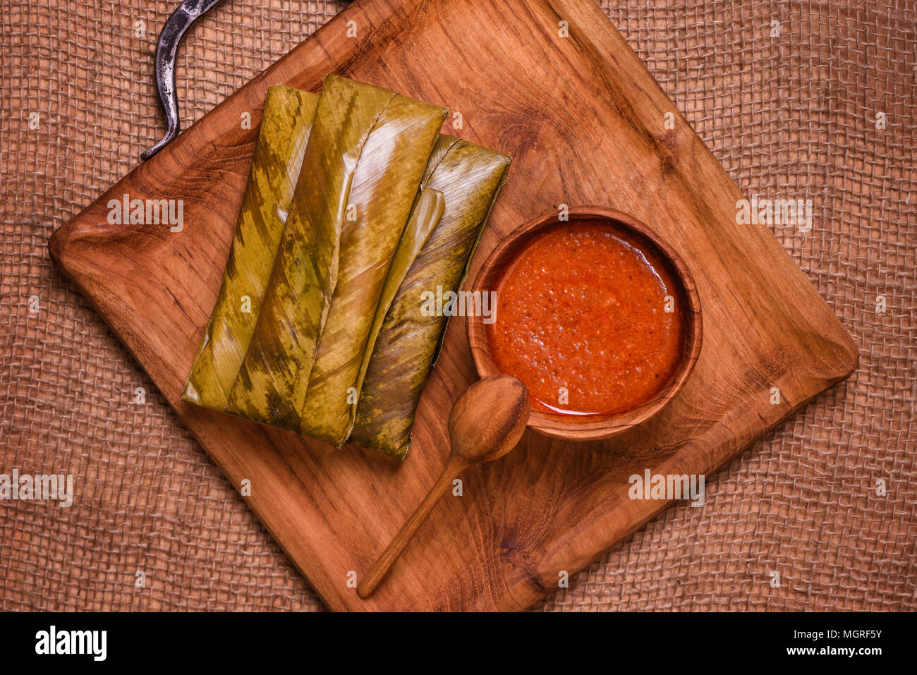top view of sticky rice wrapped in leaves and served with peanut sauce ...