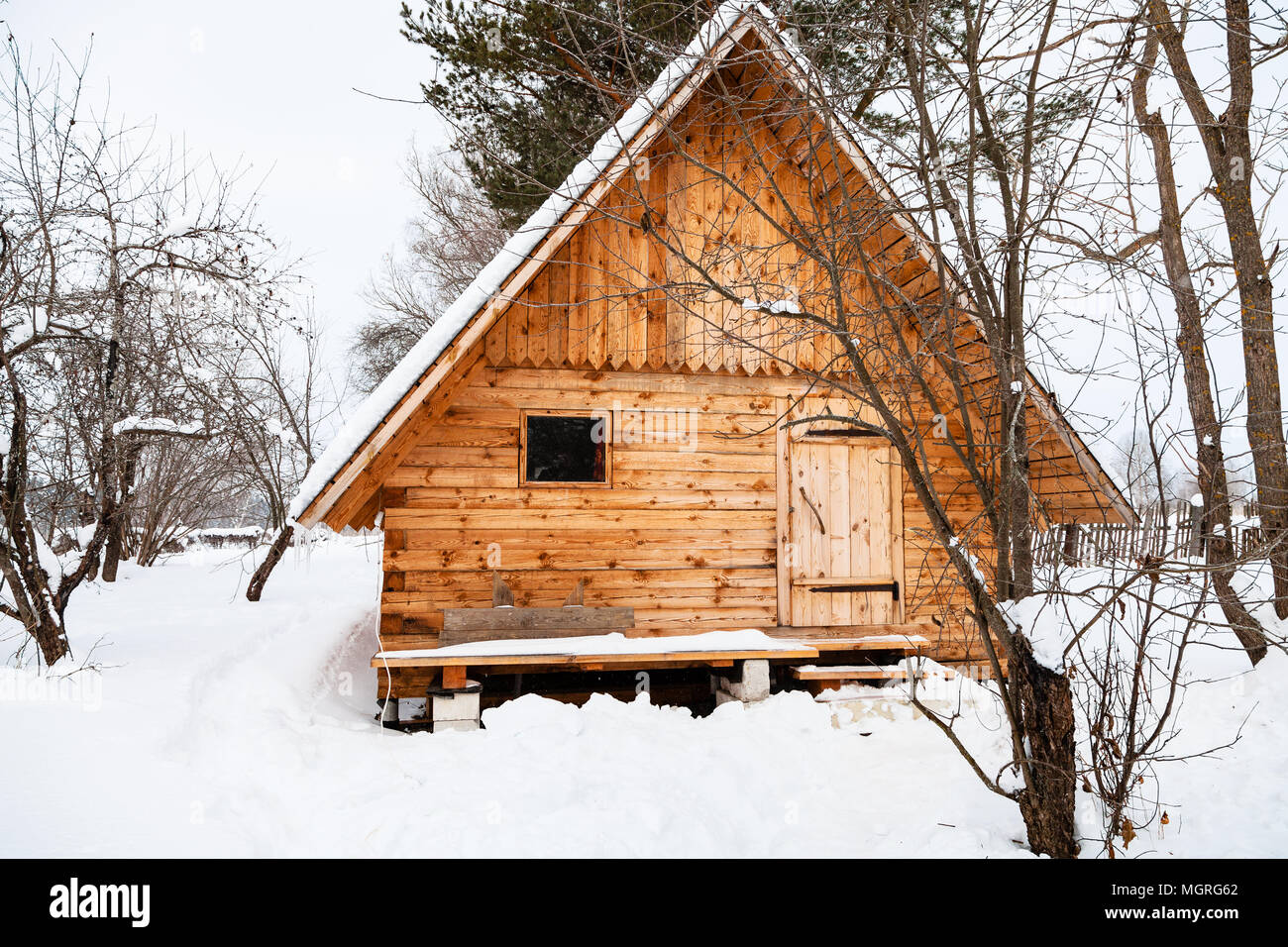 New Small Timber Cottage In Snow Covered Garden In Overcast Winter
