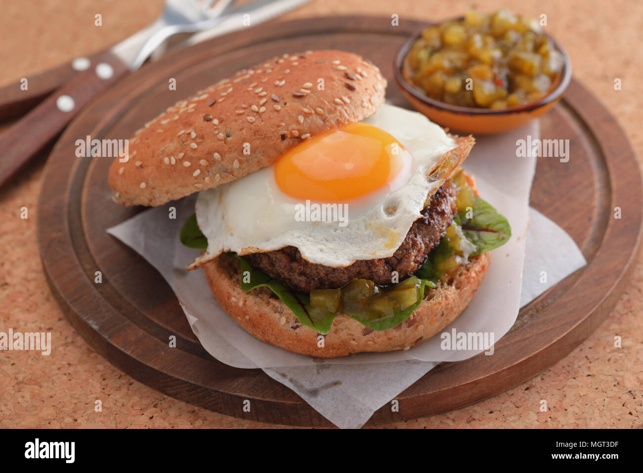 Hamburger with fried egg and gherkin salad Stock Photo Alamy