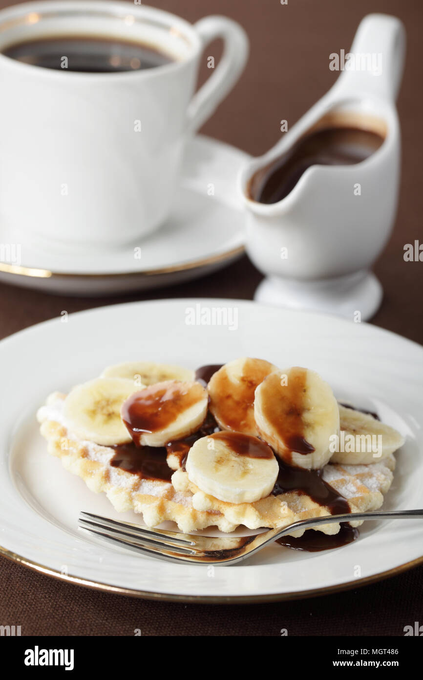 Waffle with banana under chocolate sauce closeup Stock Photo - Alamy