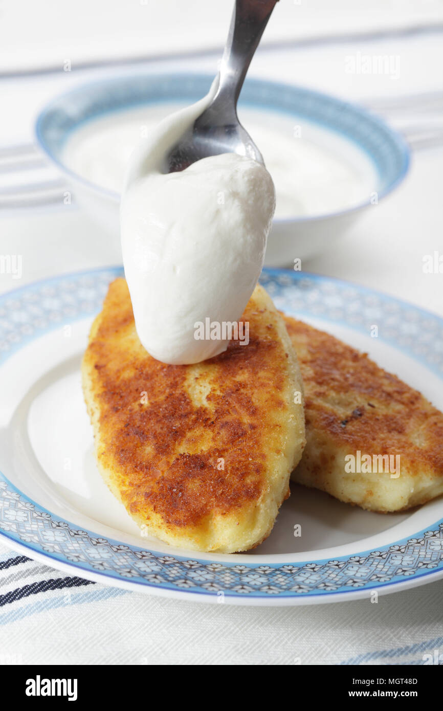 Zrazas, ukrainian potato patties with mushrooms and pouring sour cream Stock Photo