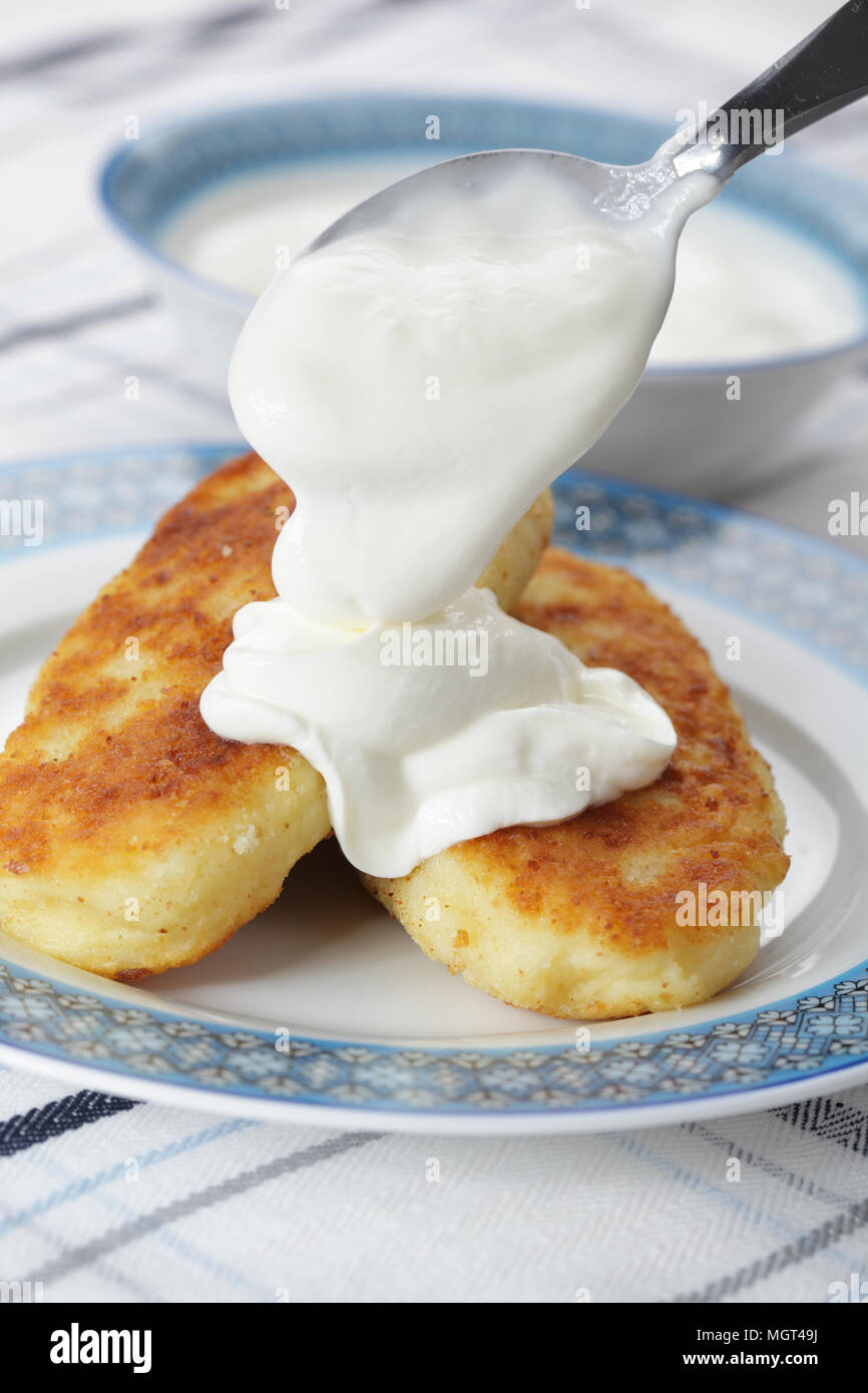 Zrazas, ukrainian potato patties with mushrooms and pouring sour cream Stock Photo