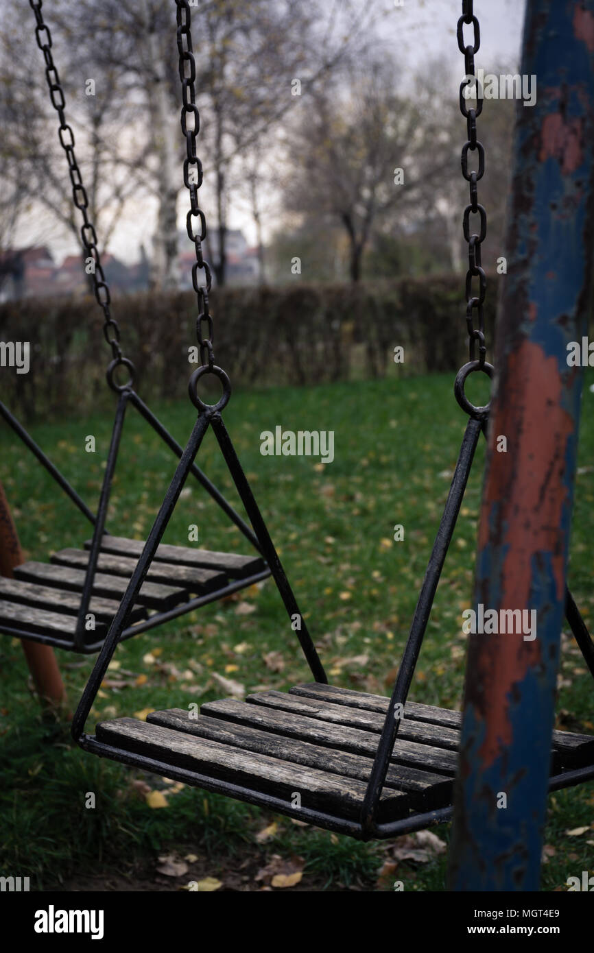 Deserted swing in children playground in autumn Stock Photo
