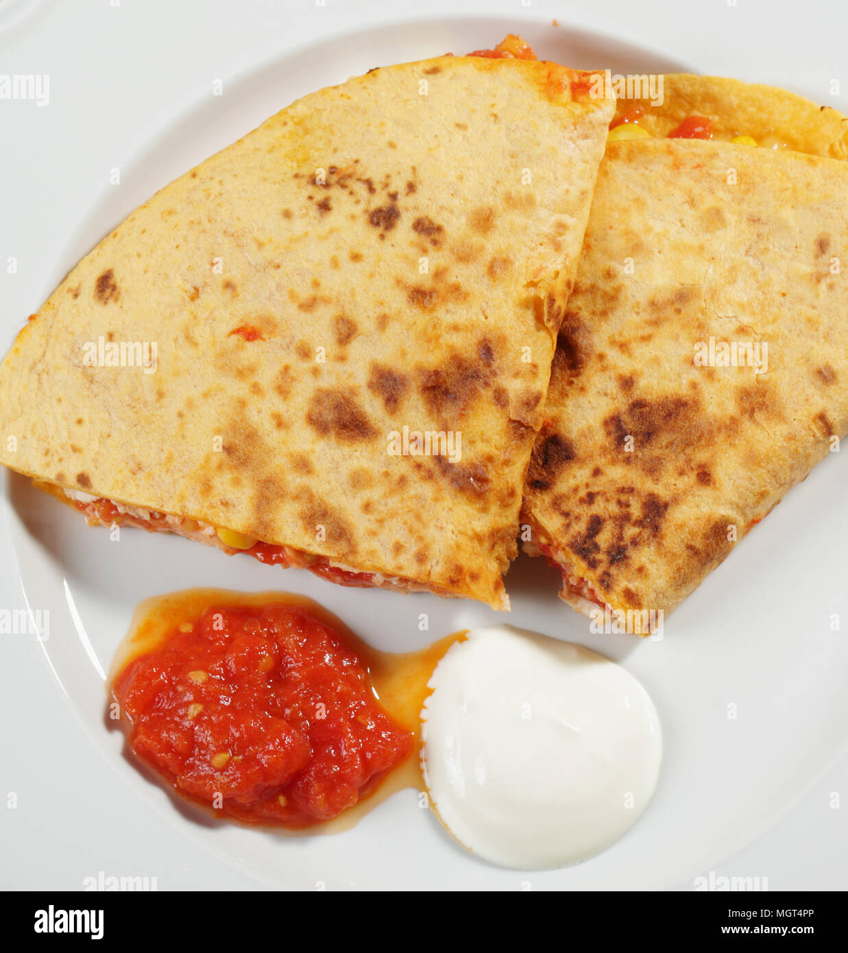 Quesadilla with chicken meat, corn, and cheese served with salsa and sour cream Stock Photo