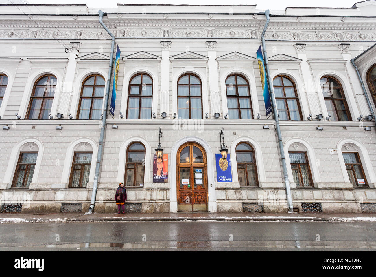 SAINT PETERSBURG, RUSSIA - MARCH 19, 2018: woman near Faberge Museum in Shuvalov Palace on Fontanka River Embankment in Saint Petersburg in snowfall.  Stock Photo