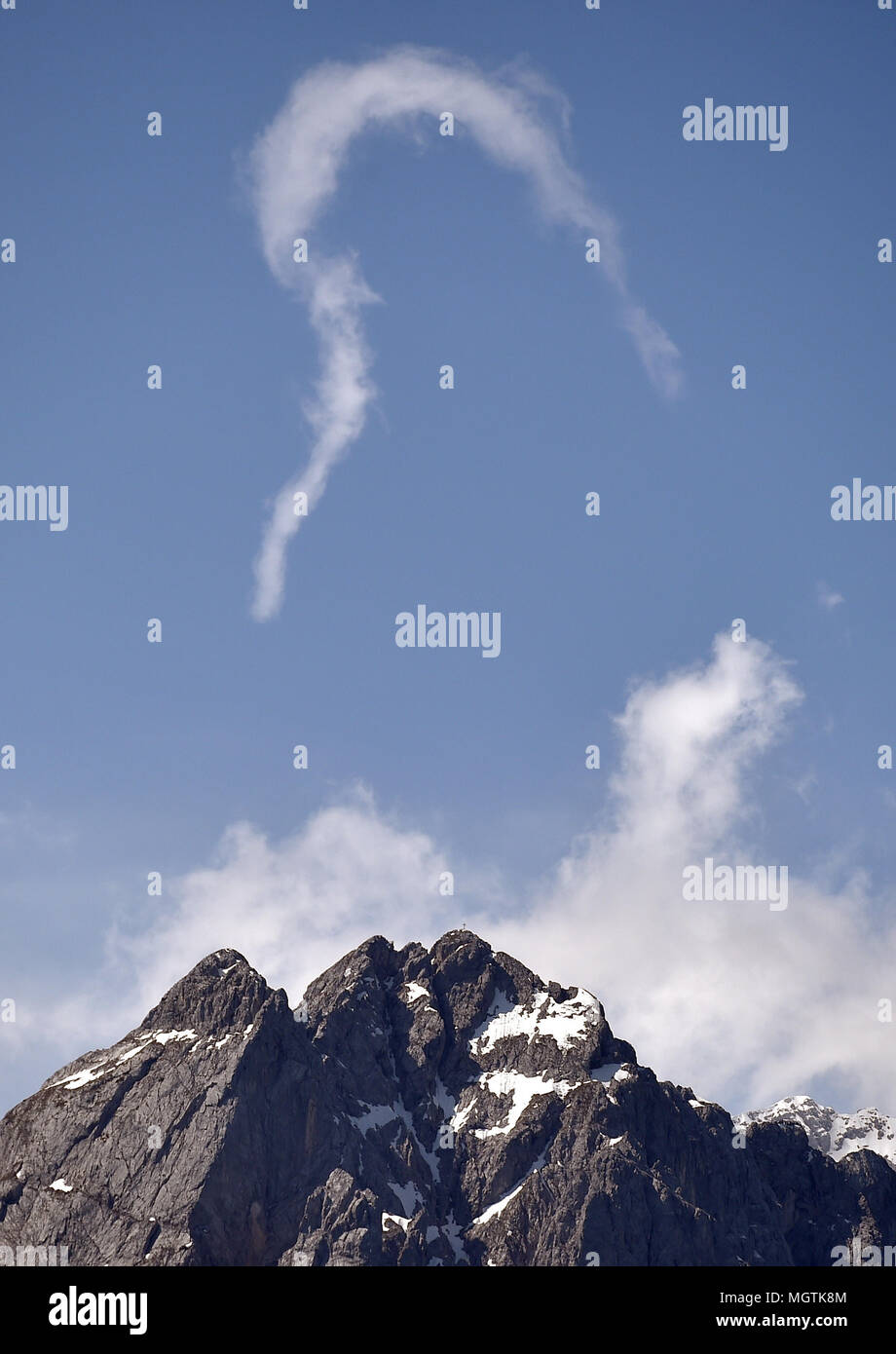 Garmisch Partenkirchen, Germany. 29th Apr, 2018. 29 April 2018, Germany, Garmisch-Partenkirchen: An airplane's contrail appearing mountain-shaped over the Waxenstein. Credit: Angelika Warmuth/dpa/Alamy Live News Stock Photo