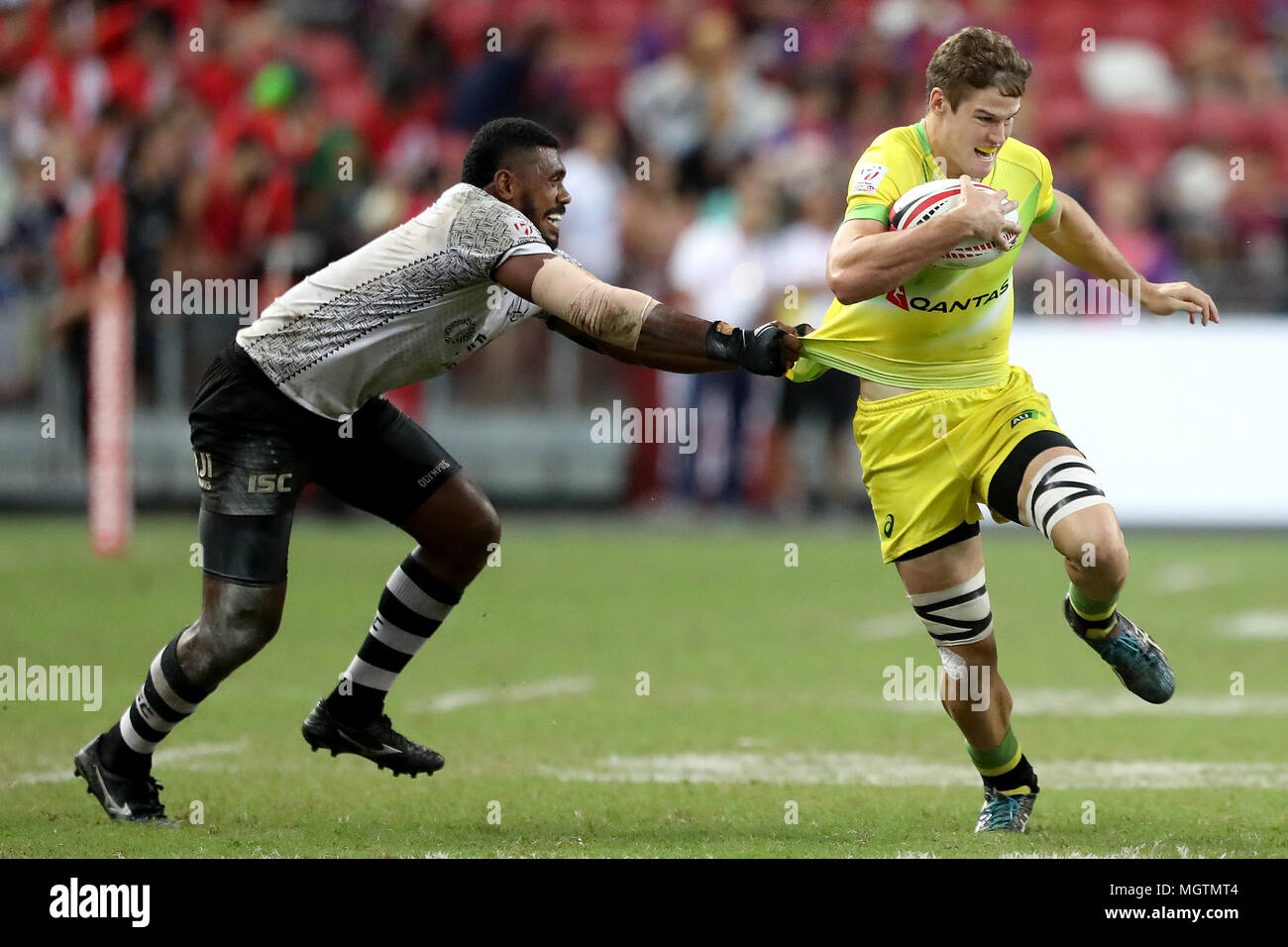 Singapore. 29th Apr, 2018. Tim Anstee (right) of Australia is tackled by Kalione Nasoko of Fiji during the Cup Final match between Fiji and Australia at the Rugby Sevens tournament at the National Stadium. Singapore. Credit: Paul Miller/ZUMA Wire/Alamy Live News Stock Photo