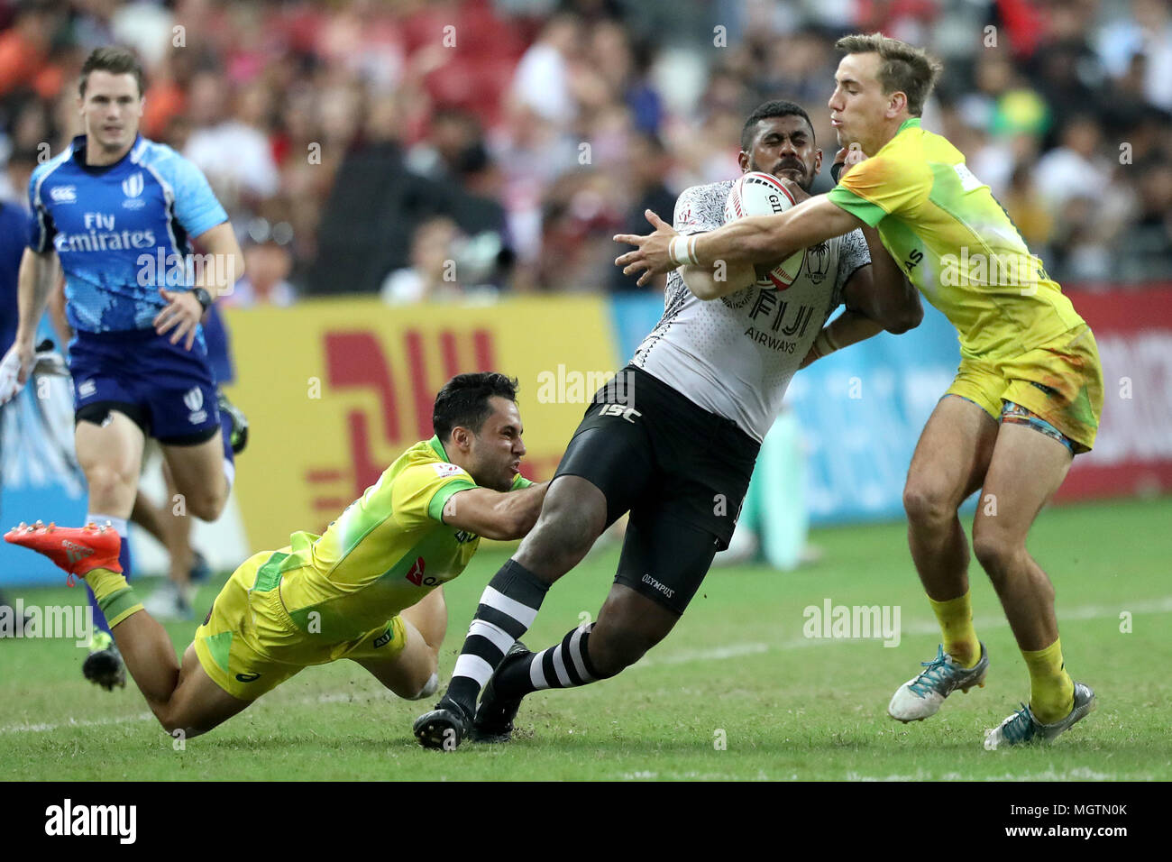 Singapore. 29th Apr, 2018. Kalione Nasoko (centre) of Fiji is tackled by Bradon Quinn (left) and John Porch of Australia during the Cup Final match between Fiji and Australia at the Rugby Sevens tournament at the National Stadium. Singapore. Credit: Paul Miller/ZUMA Wire/Alamy Live News Stock Photo