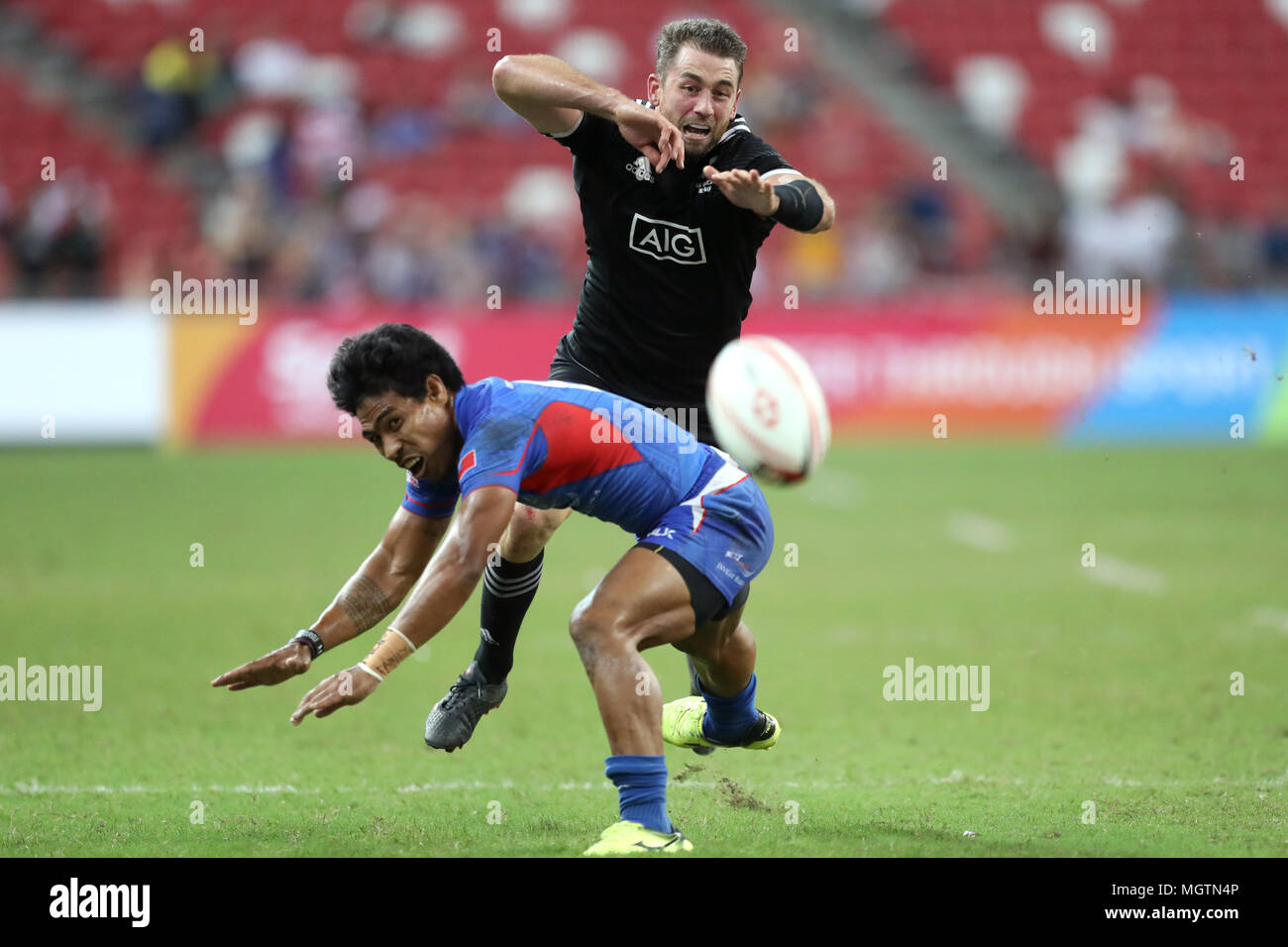 Singapore. 29th Apr, 2018. Kurt Baker of New Zealand (right) competes for the ball with Murphy Paulo of Samoa during the Cup fifth place play off match between New Zealand and Samoa at the Rugby Sevens tournament at the National Stadium. Singapore. Credit: Paul Miller/ZUMA Wire/Alamy Live News Stock Photo